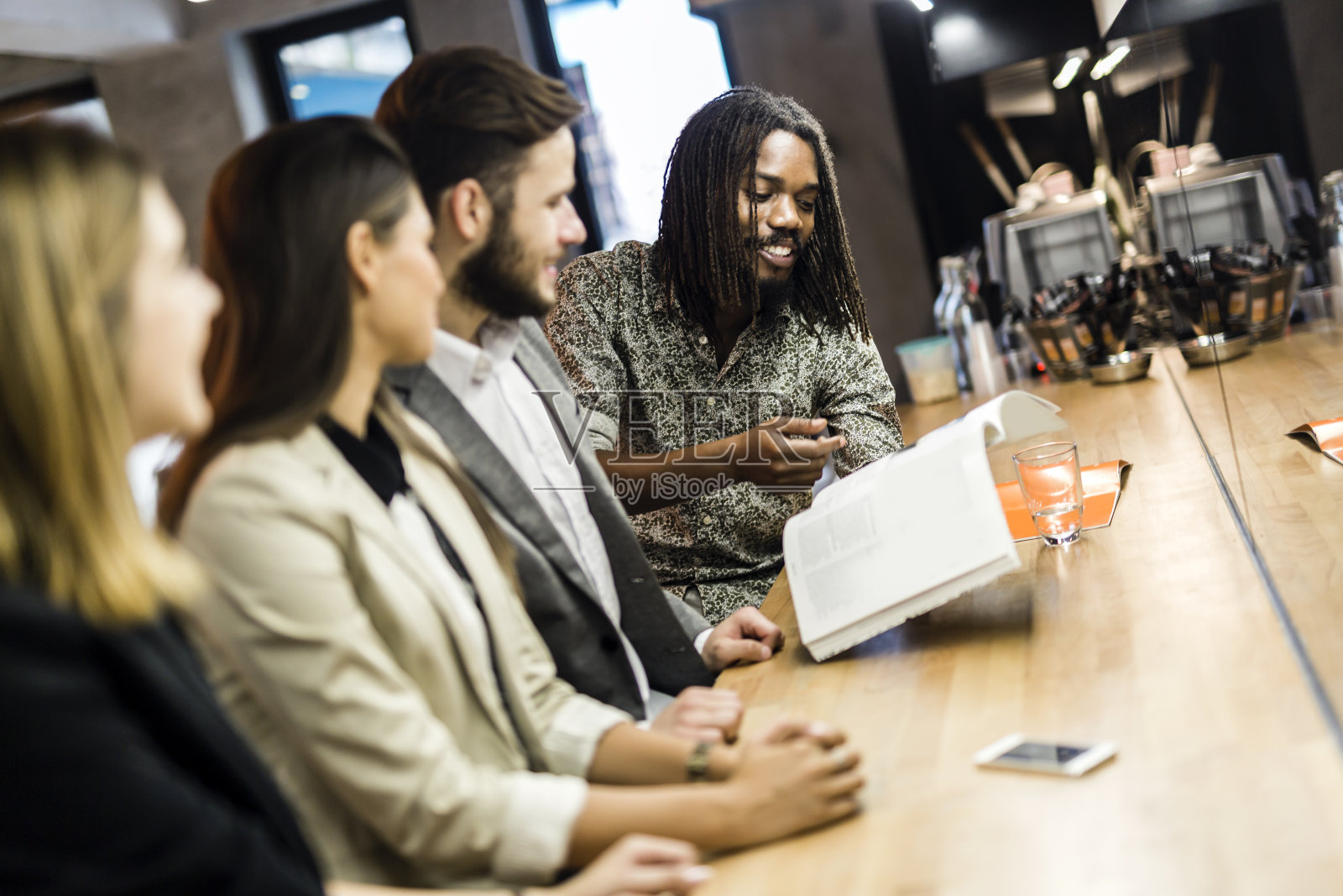 坐在酒吧里讨论文章内容的一群人照片摄影图片