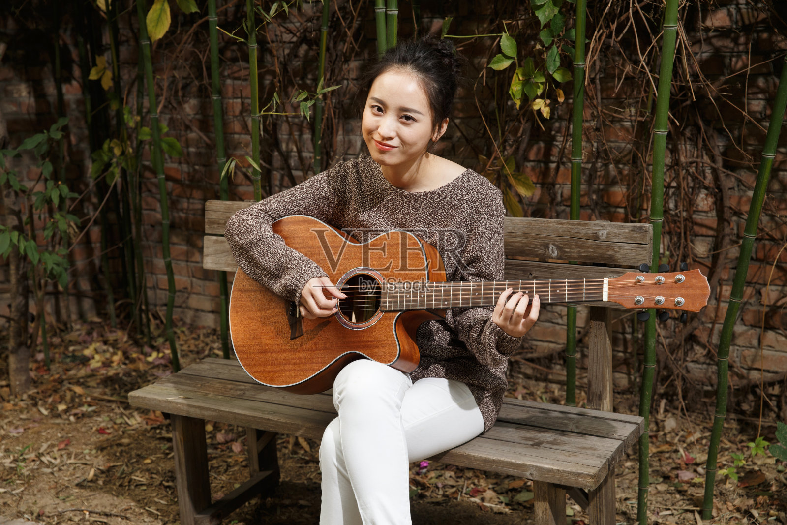 快乐的年轻女子在弹吉他照片摄影图片