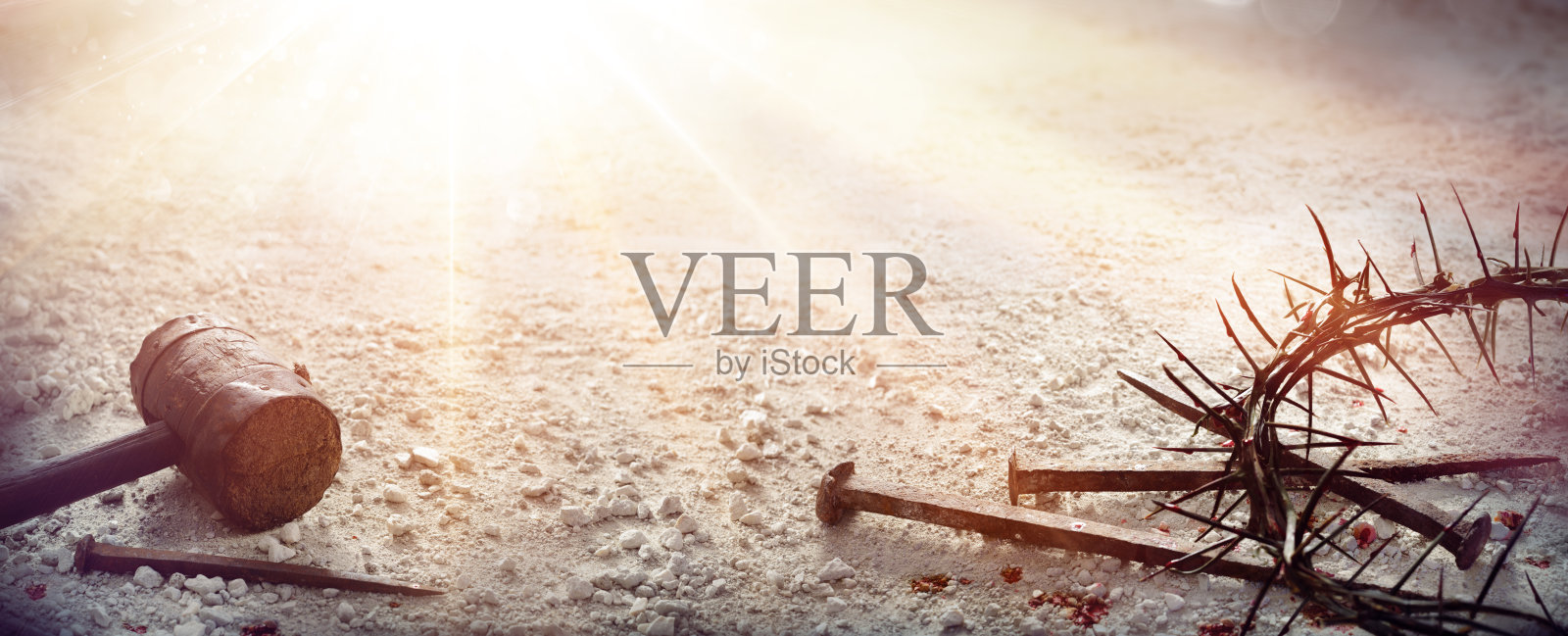 耶稣基督的受难-乾旱地上的锤子、血钉和荆棘冠照片摄影图片