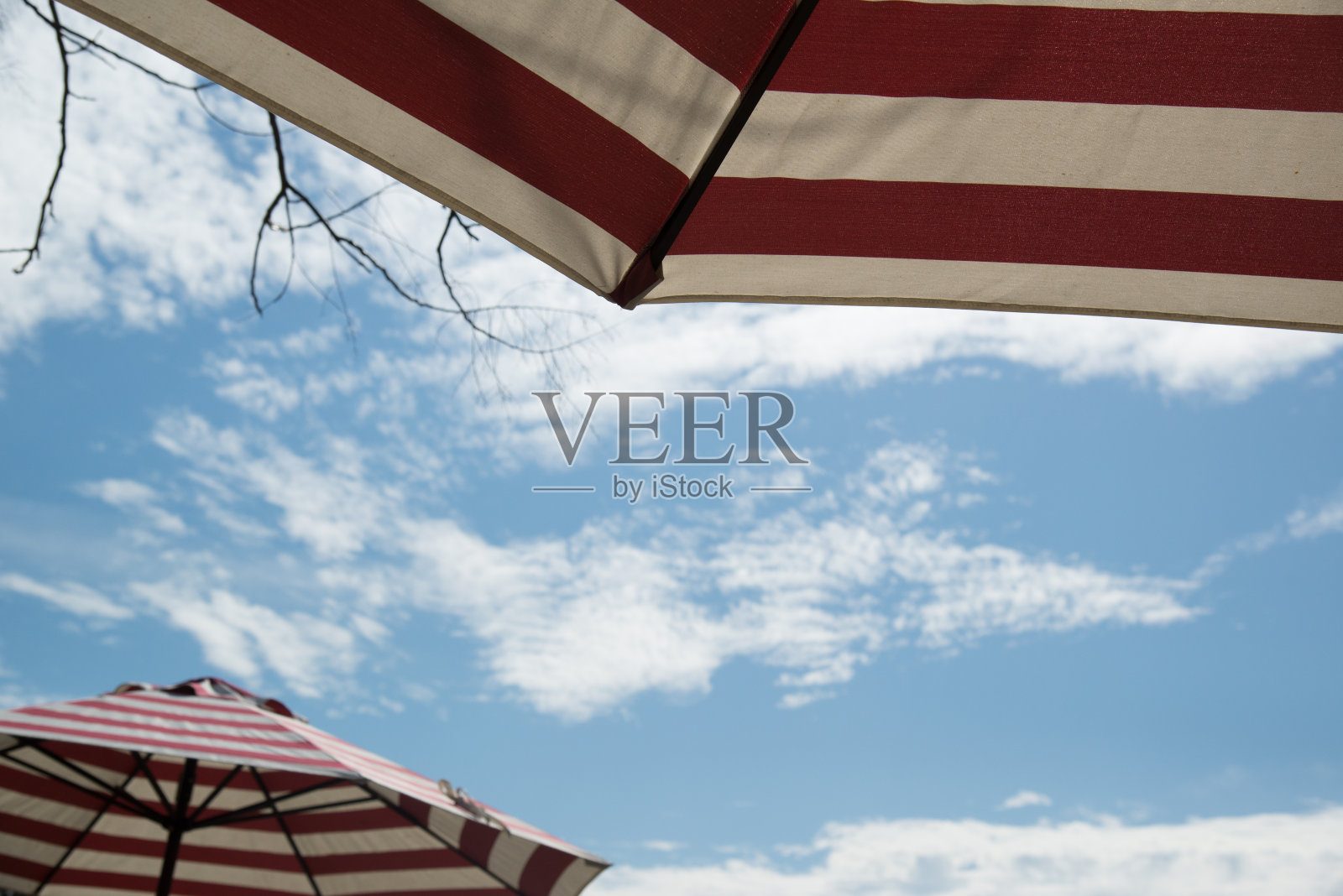 红白相间的伞带着蓝天照片摄影图片