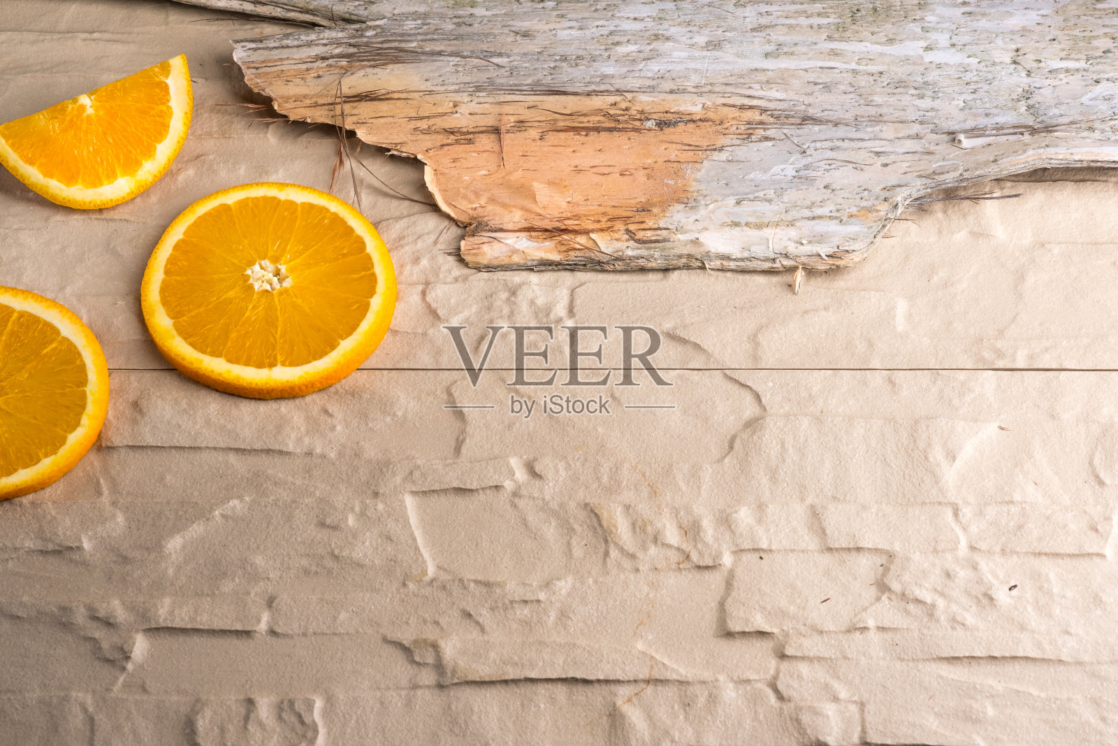 石头表面的桔子片和树皮照片摄影图片