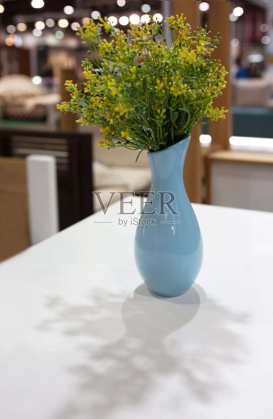 桌上的花瓶里插着花，背景是灯光照片摄影图片