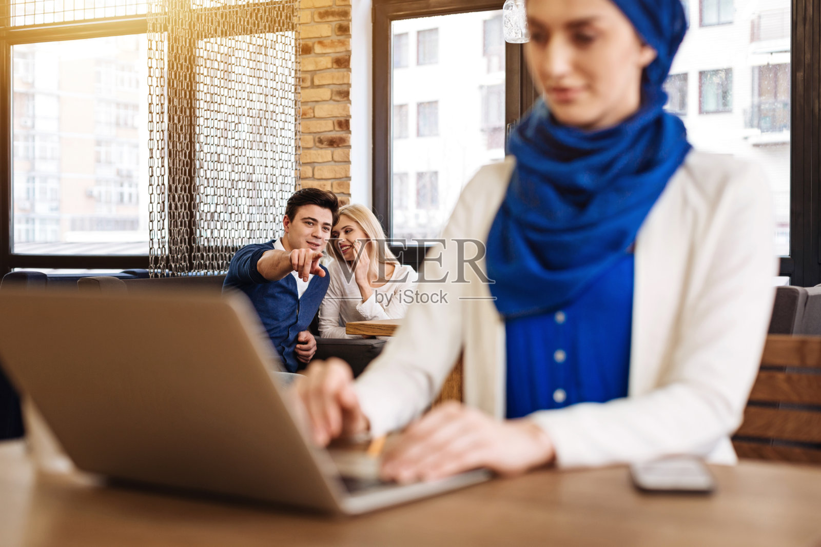 一对积极的夫妇指着穆斯林妇女照片摄影图片