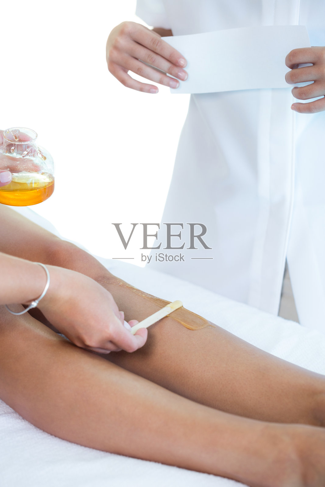 一个女人正在给她的腿打蜡照片摄影图片