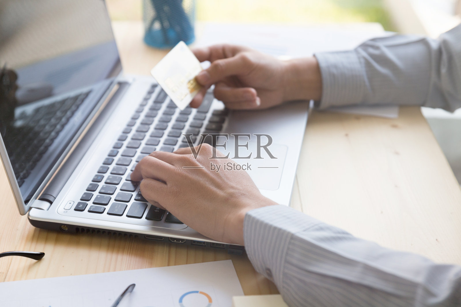 商人手持信用卡，准备用笔记本电脑进行在线支付照片摄影图片