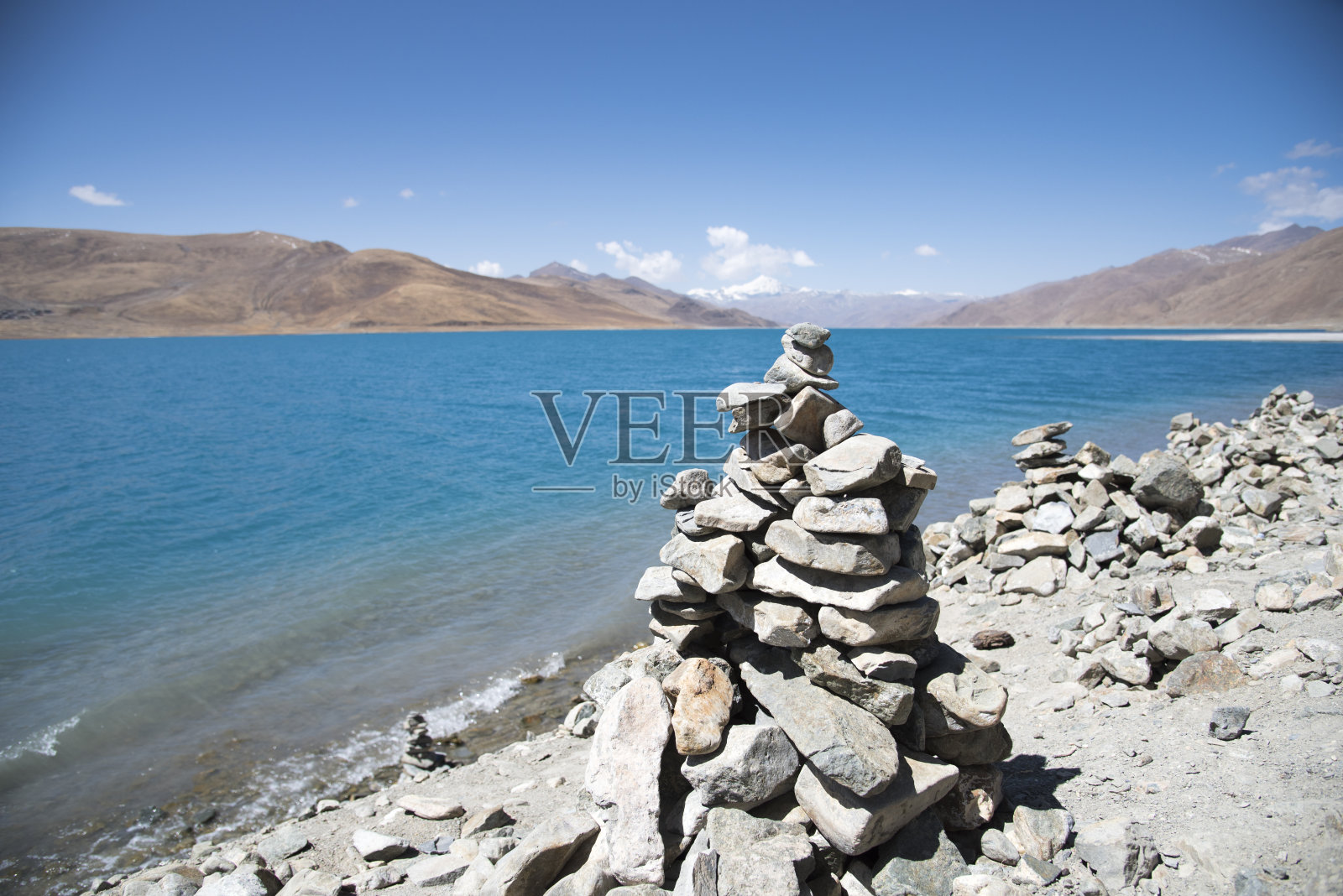 在西藏的一个圣湖前堆积的石头照片摄影图片