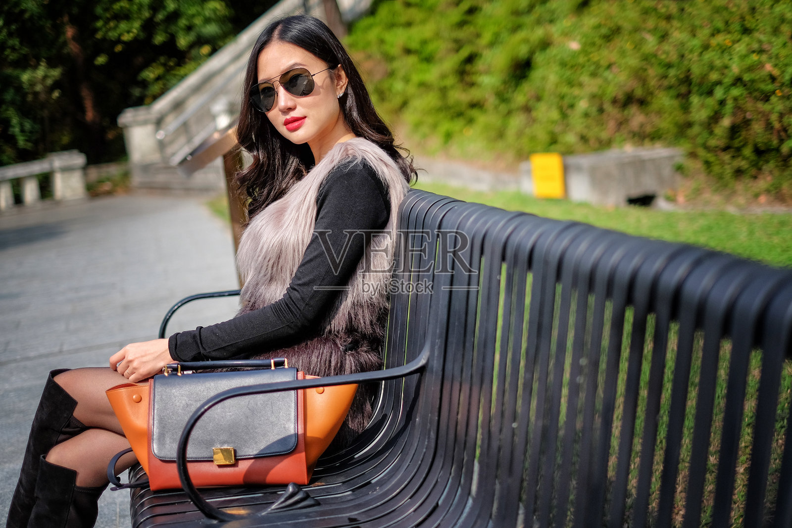 美丽的年轻女子太阳镜在公园休息照片摄影图片