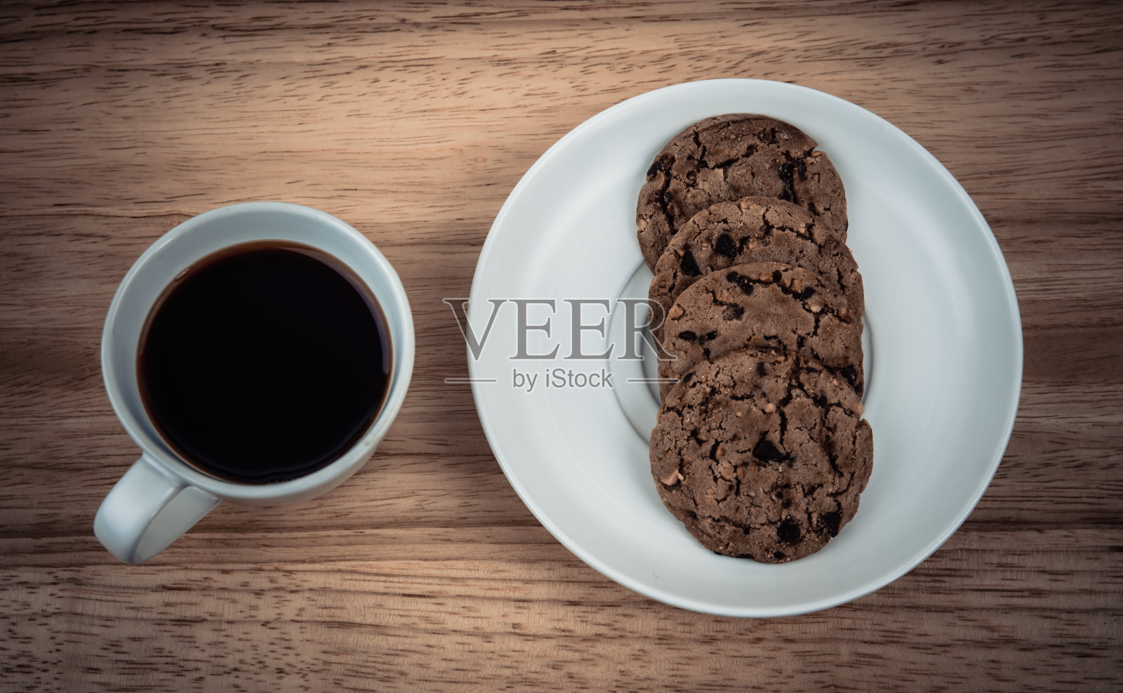 木桌上放着一杯咖啡和饼干照片摄影图片
