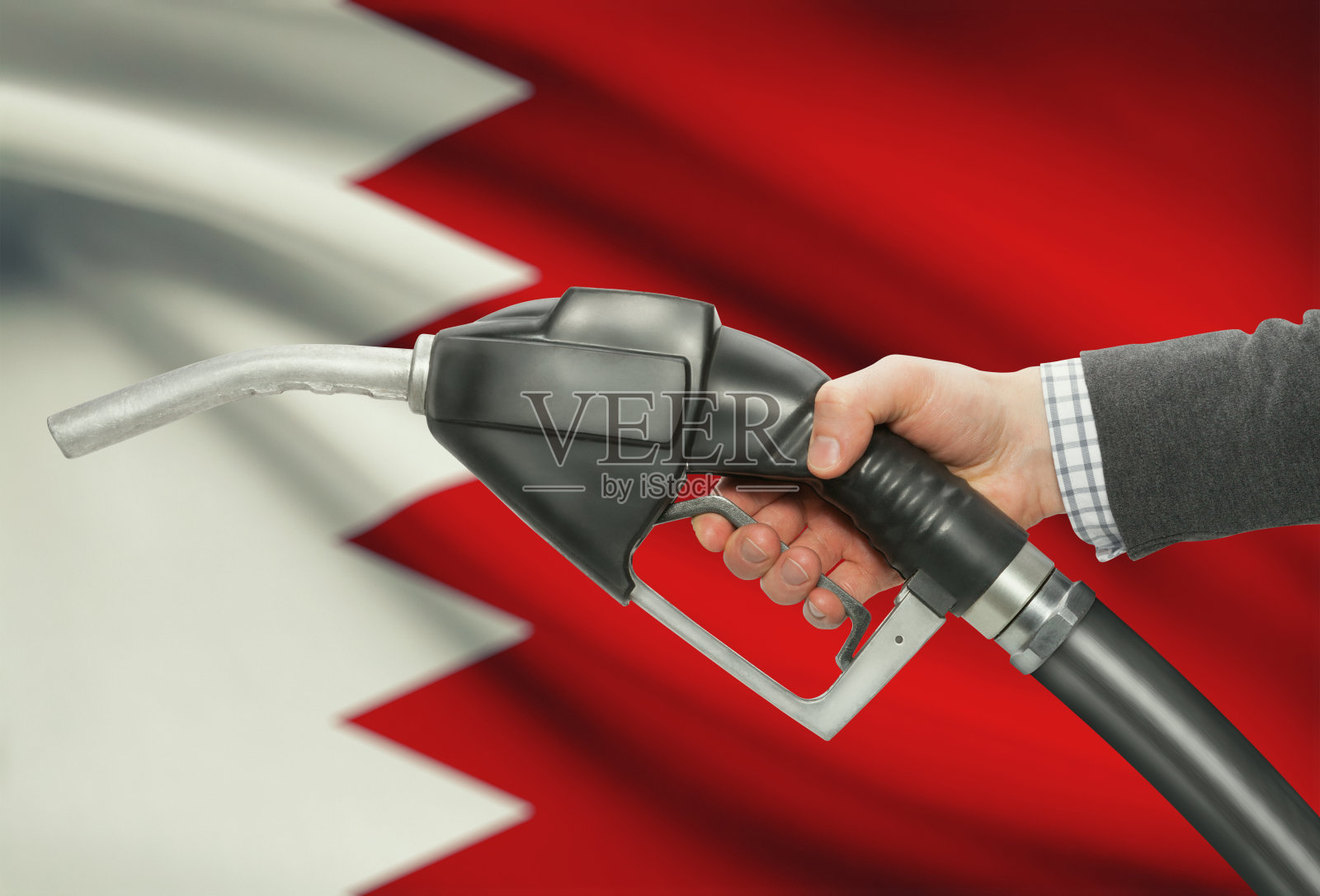 手持带国旗的燃油泵喷嘴 - 巴林照片摄影图片