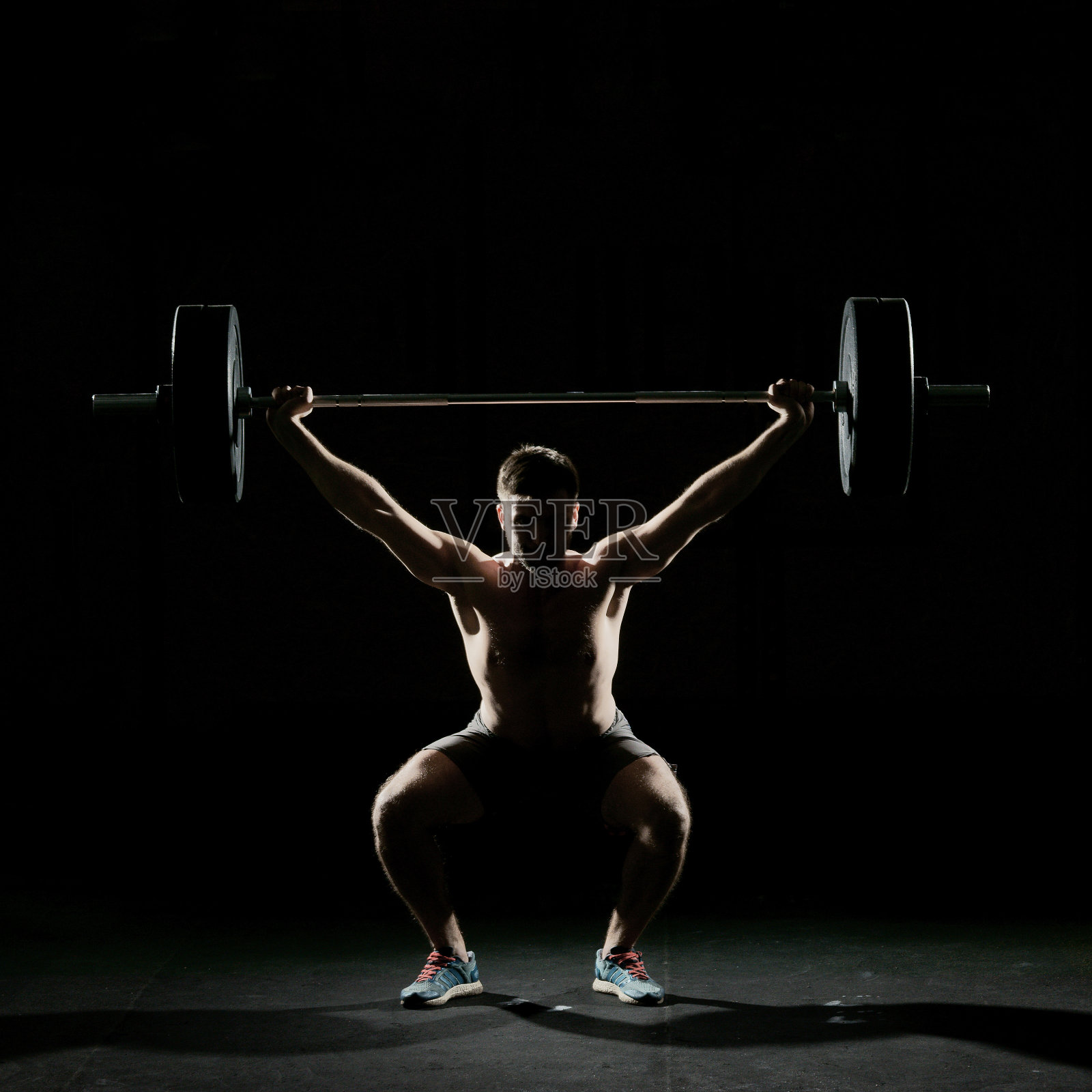 健身训练。用杠铃做仰卧起坐的人照片摄影图片