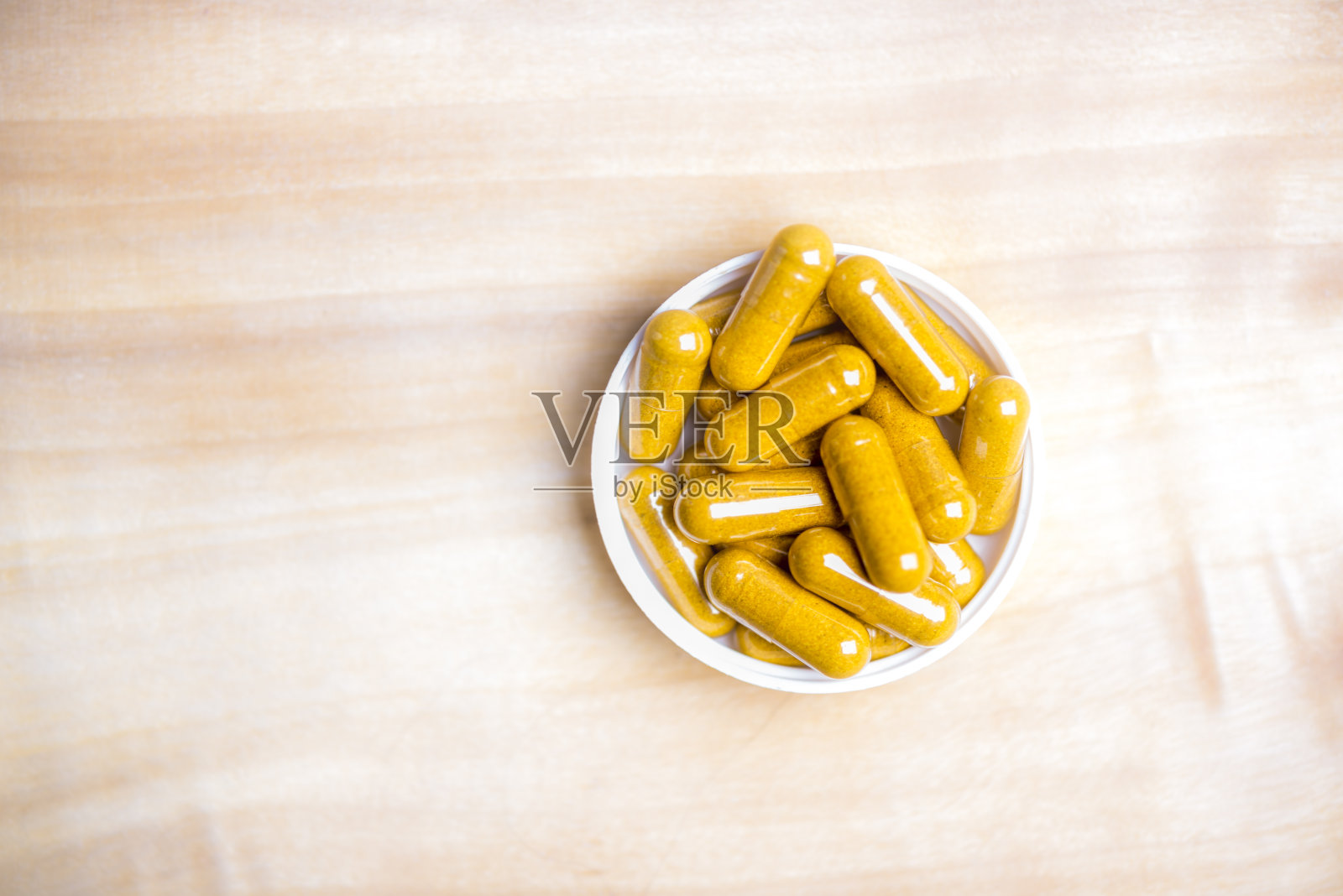 姜黄胶囊装在木桌上照片摄影图片
