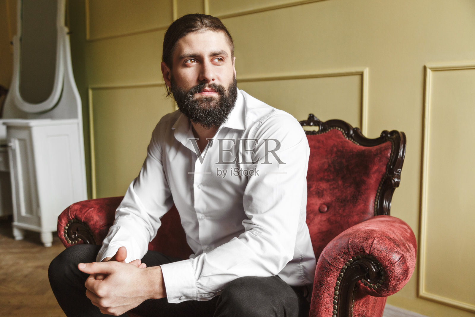 坐在红椅子上的帅哥照片摄影图片