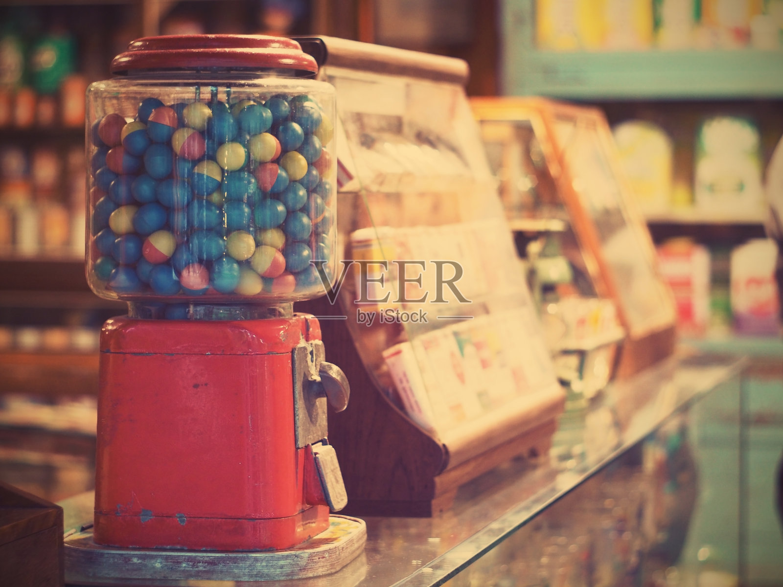 在杂货店玻璃柜台上的老式口香糖机里赌博鸡蛋，老式的过滤效果照片摄影图片