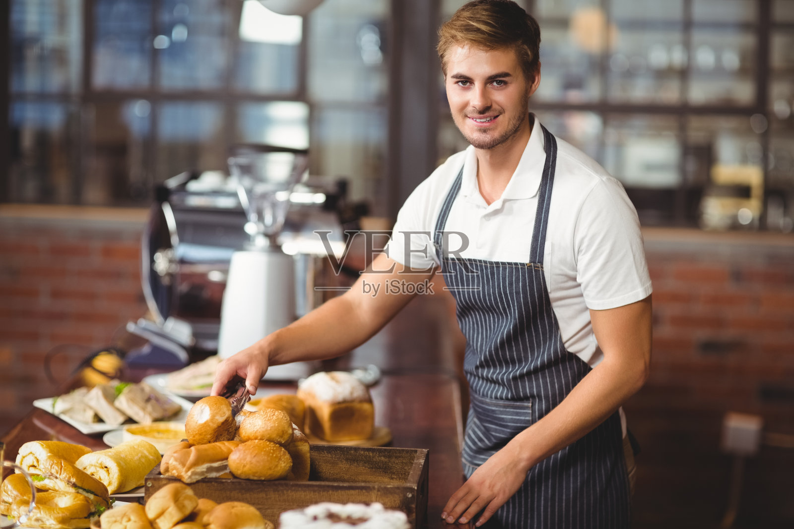 帅气的侍者拿起一卷面包照片摄影图片