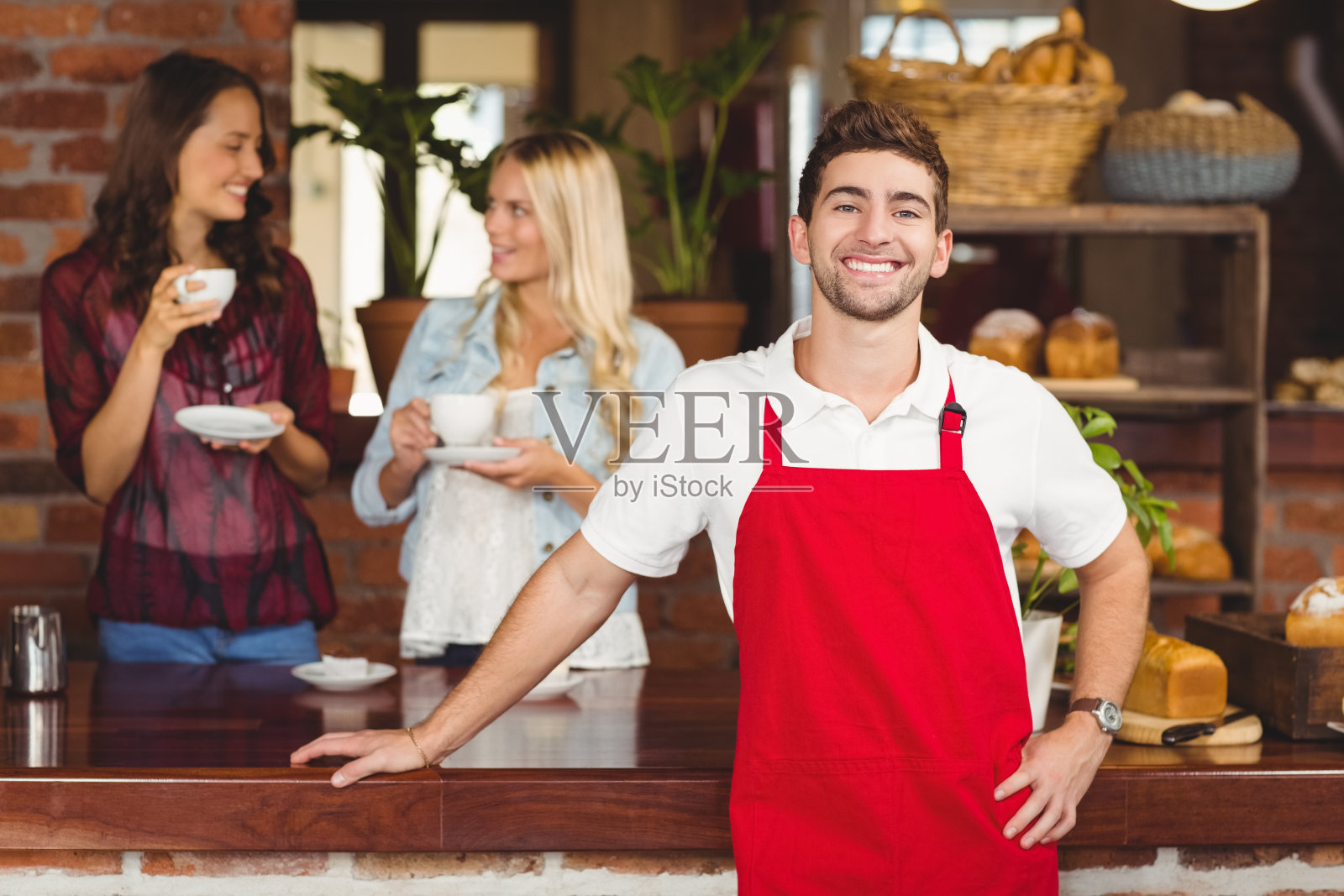 英俊的侍者靠在柜台上照片摄影图片