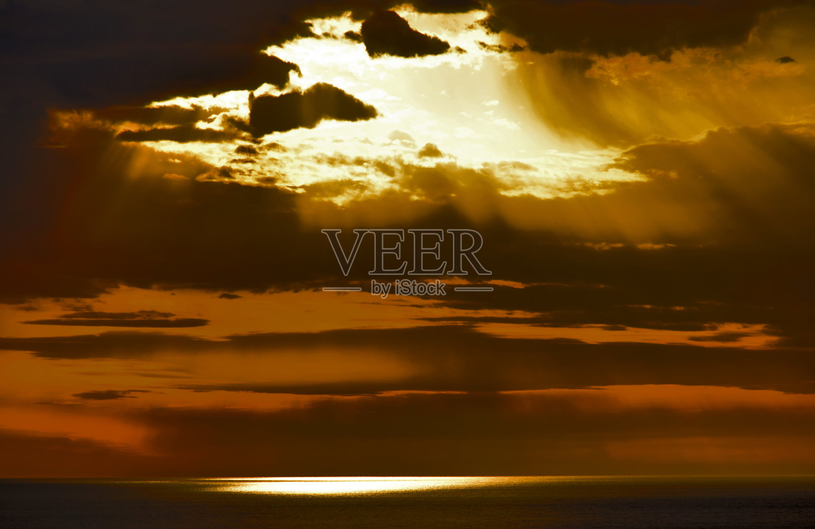 海面上的日落，天空多云照片摄影图片