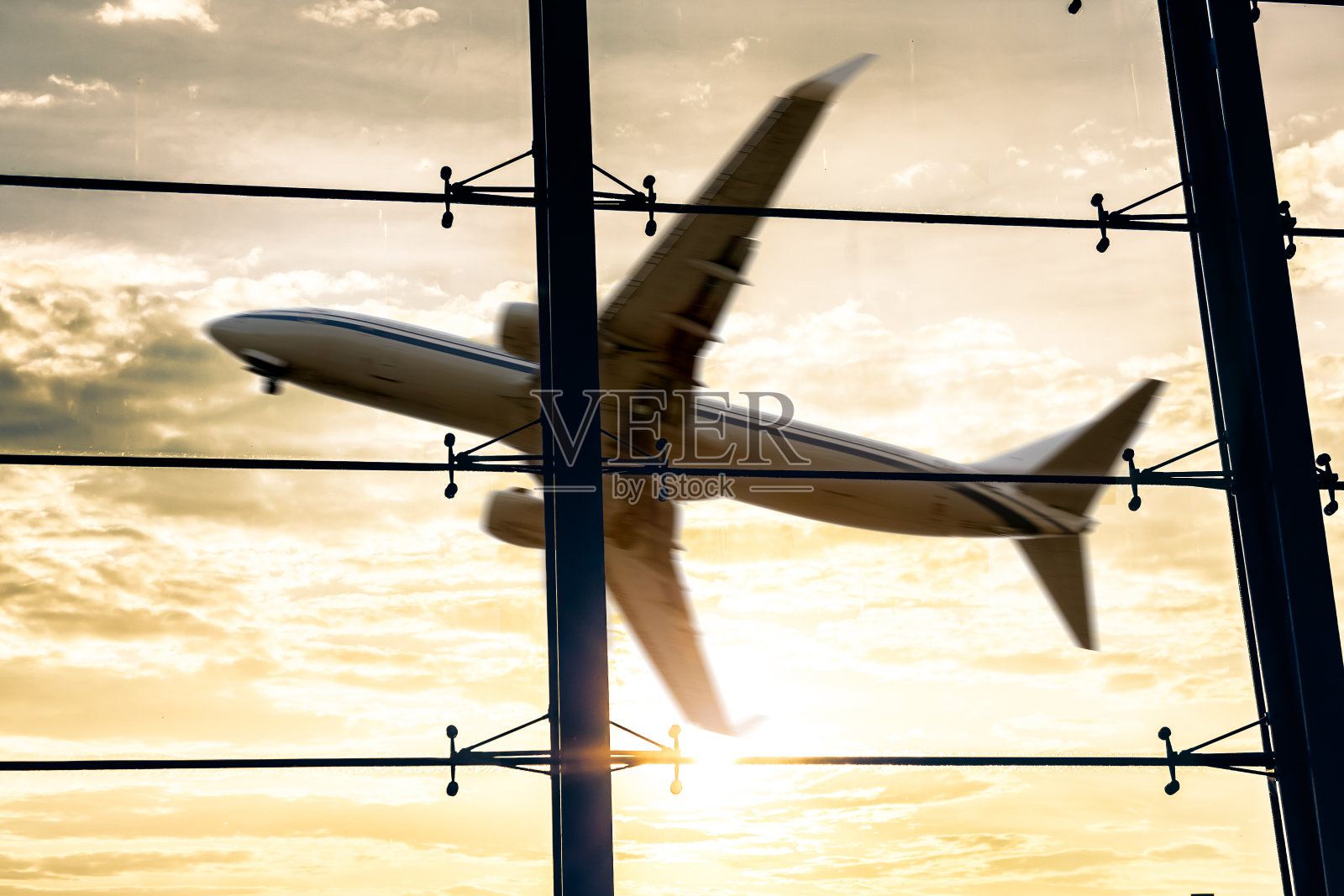 日落时的机场窗户和飞机照片摄影图片