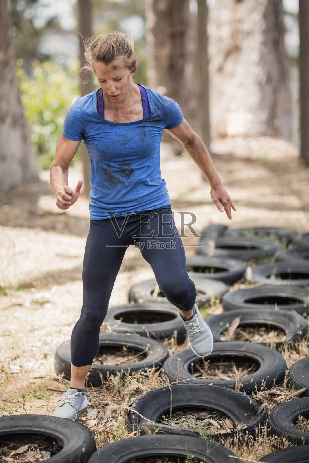 一名女子在障碍赛中压过了轮胎照片摄影图片