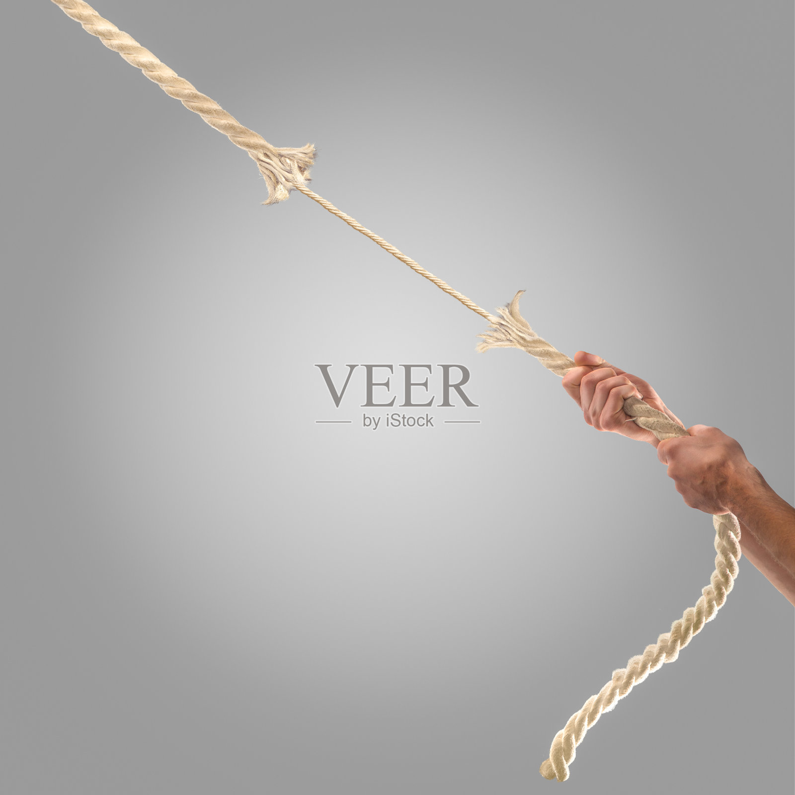 在灰色的背景上，人们拉着绳子的手。照片摄影图片