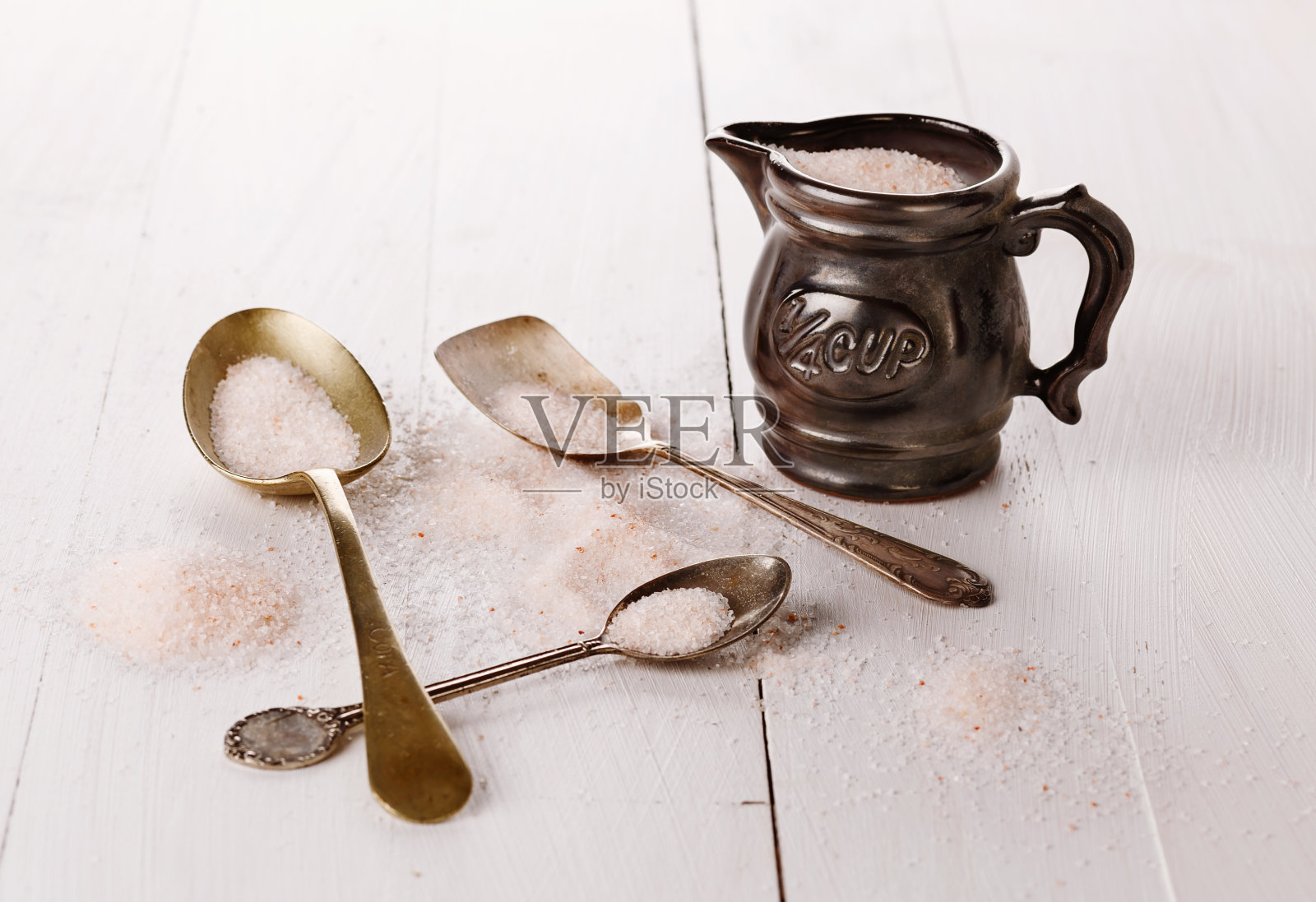 木质背景上的一个量杯里的喜马拉雅粉盐照片摄影图片