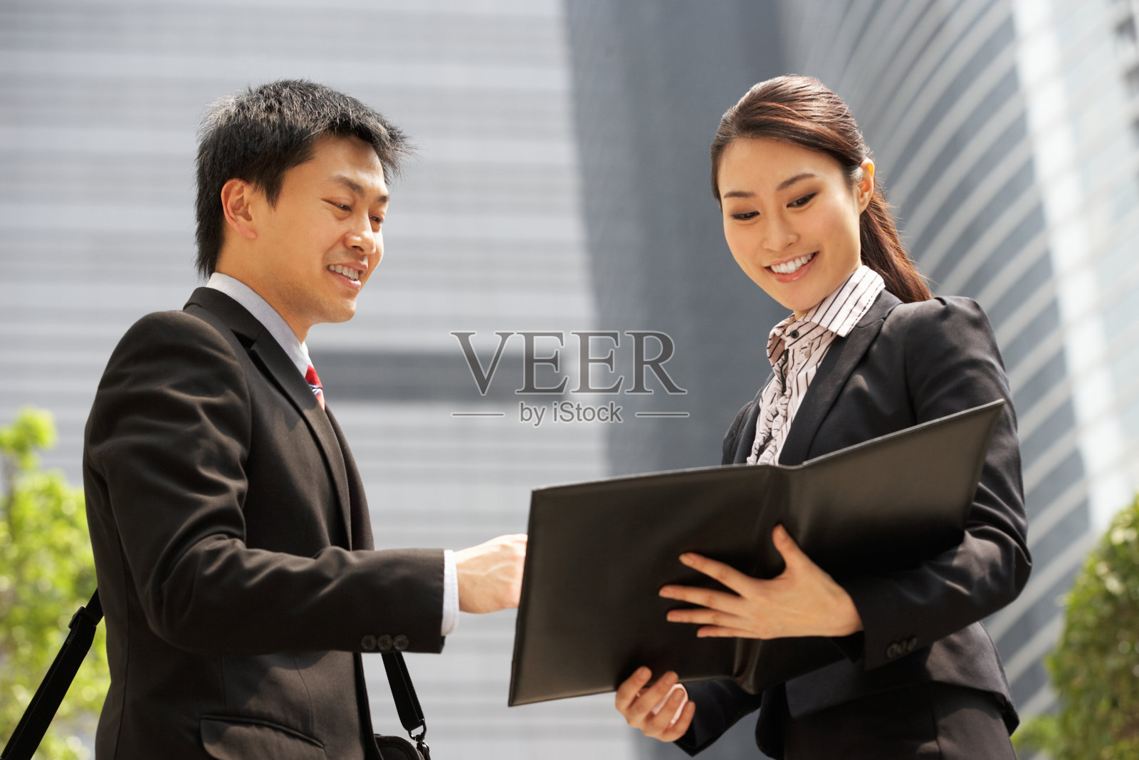 中国商人和女商人在外面讨论文件照片摄影图片