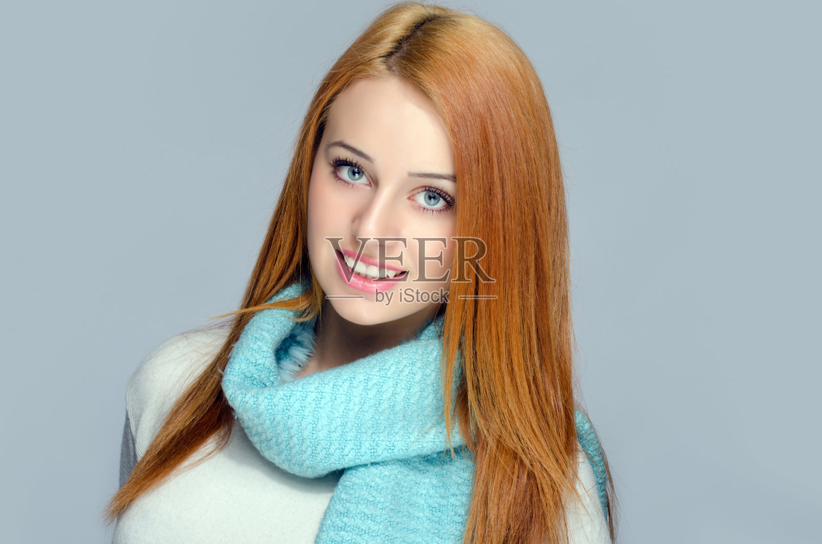 一个漂亮的红发女人戴着蓝色围巾的肖像照片摄影图片