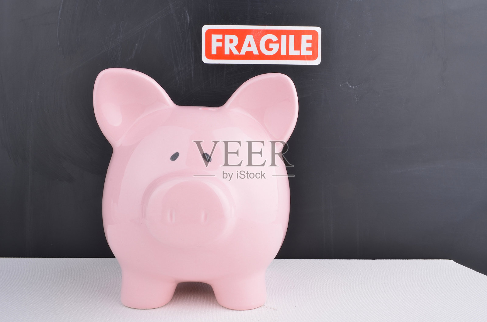 黑板前的粉色储蓄罐照片摄影图片