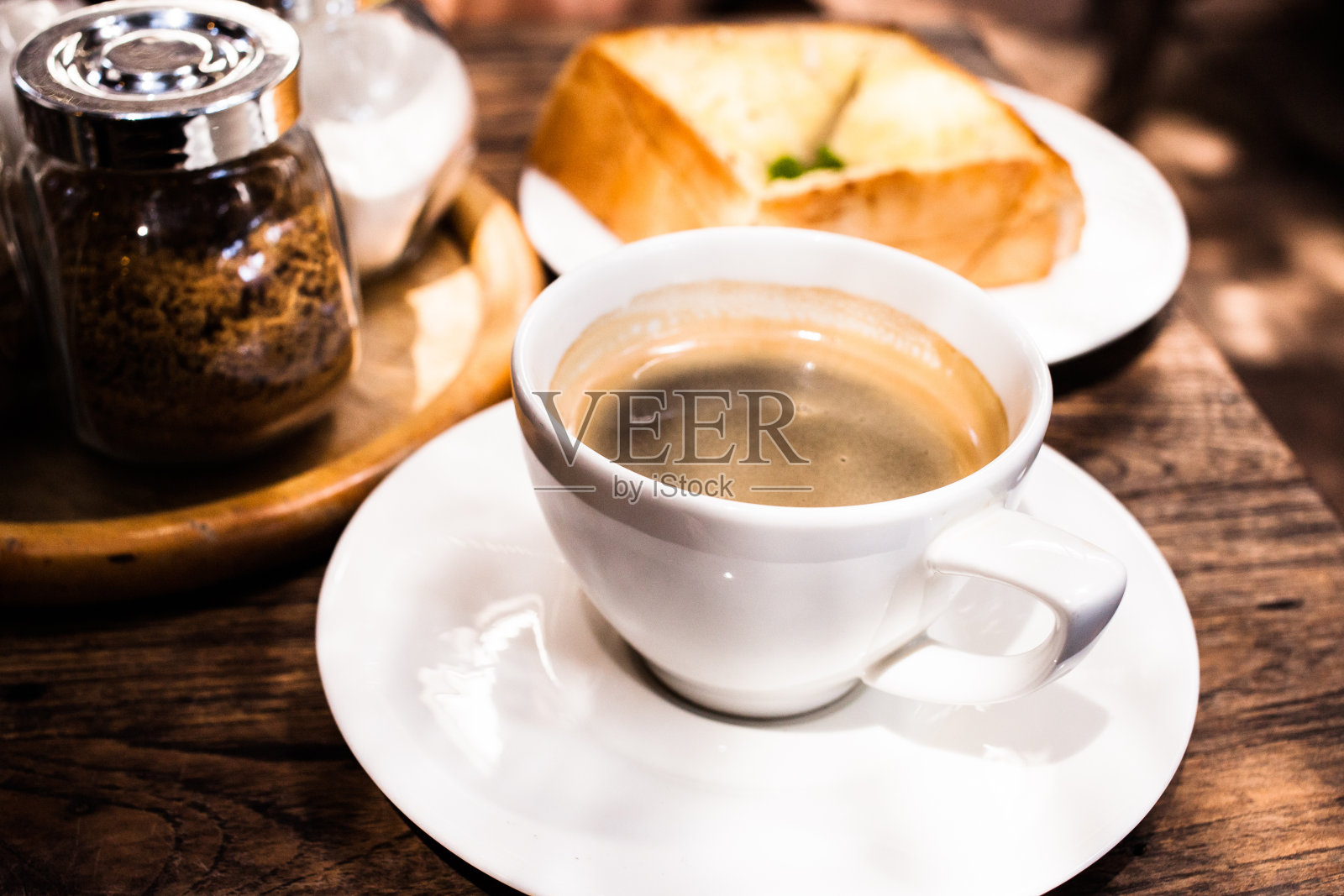 桌上放着美式黑咖啡和大蒜面包。照片摄影图片