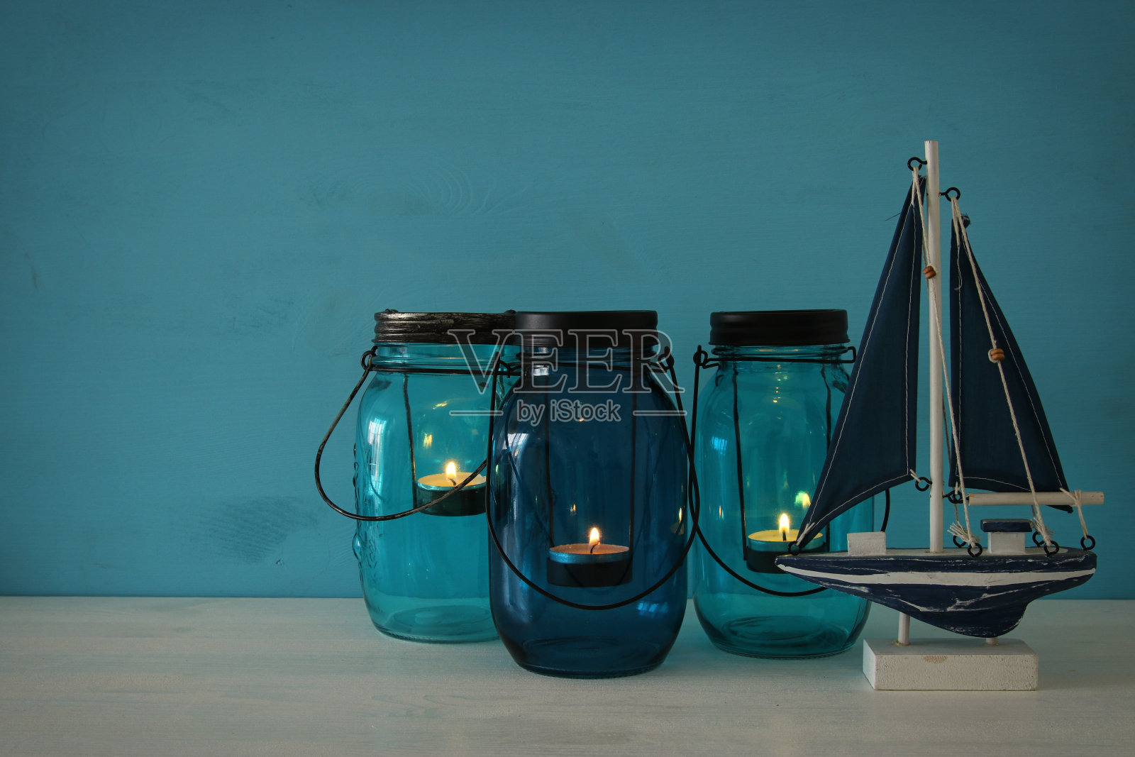 神奇的石匠罐子，上面放着蜡烛和架子上的木船照片摄影图片