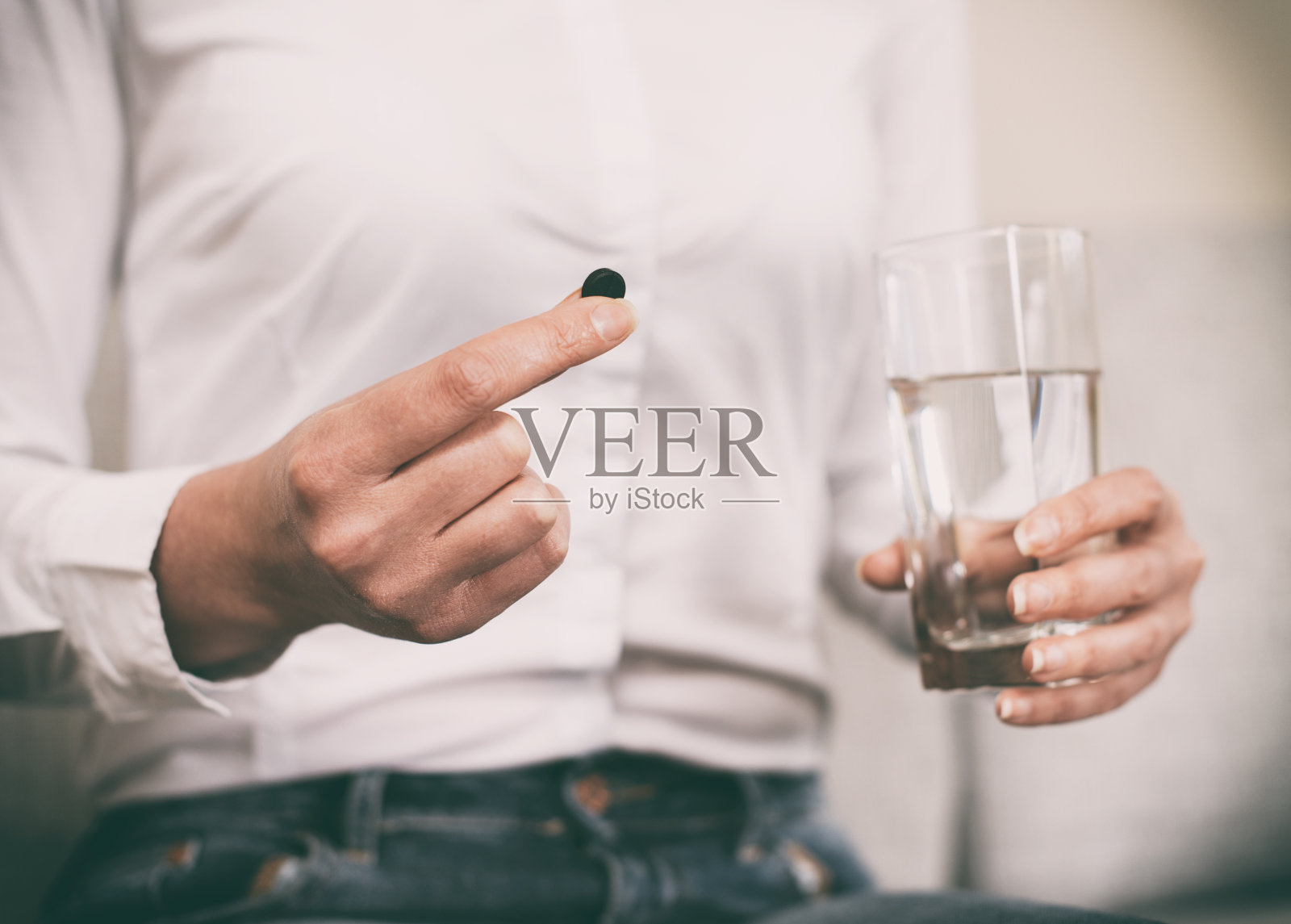 女人的手握活性炭丸。照片摄影图片