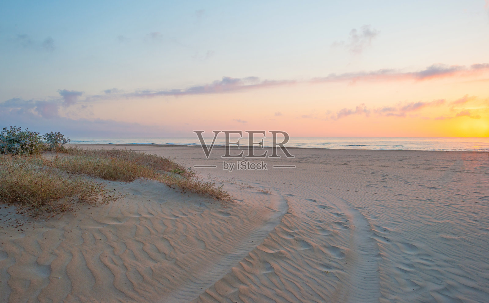 春天，海面和沙滩上的日出照片摄影图片