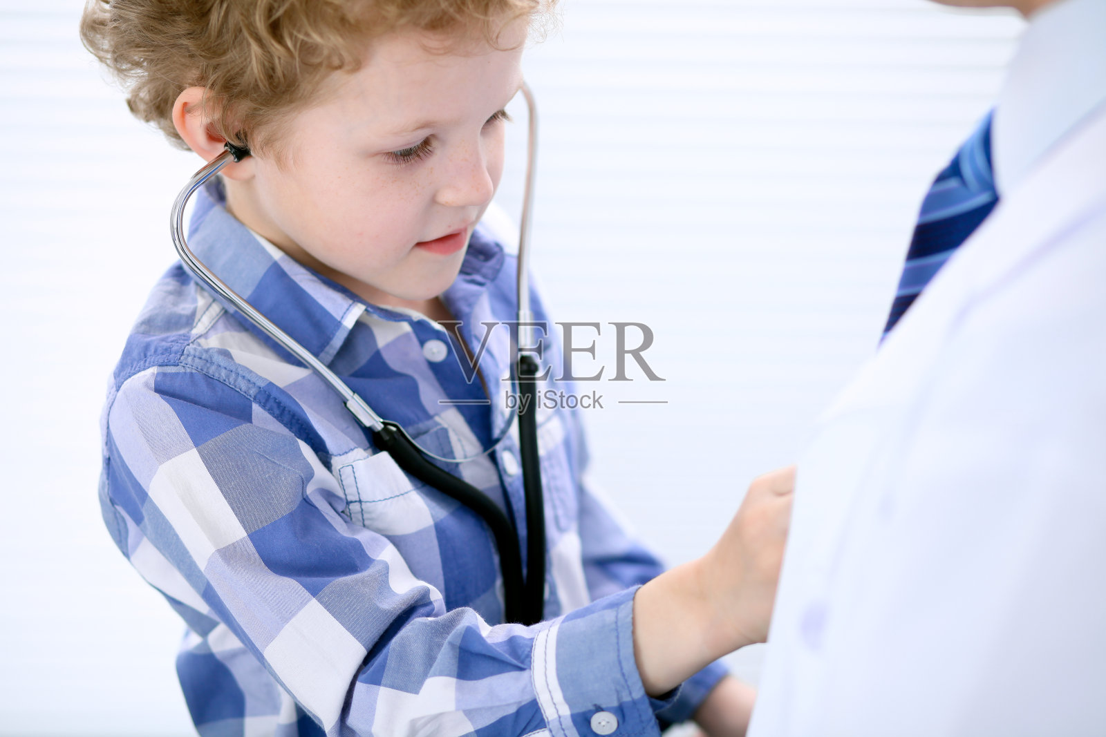 儿童病人正在用听诊器检查他的医生照片摄影图片