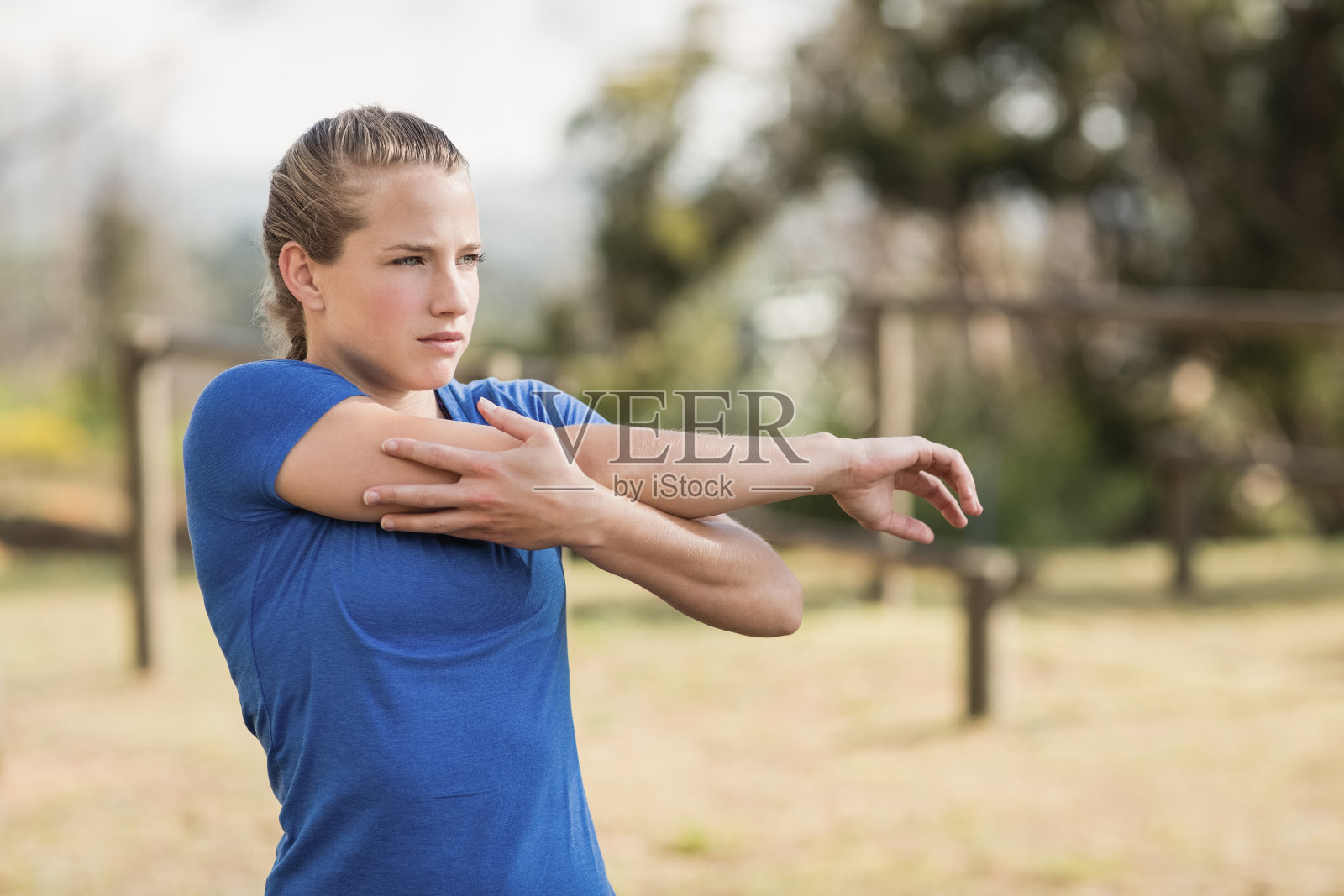 健身妇女在障碍赛期间进行伸展运动照片摄影图片