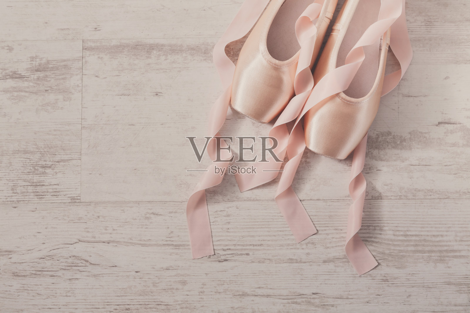 粉红色芭蕾舞尖头鞋在白色的木头背景照片摄影图片