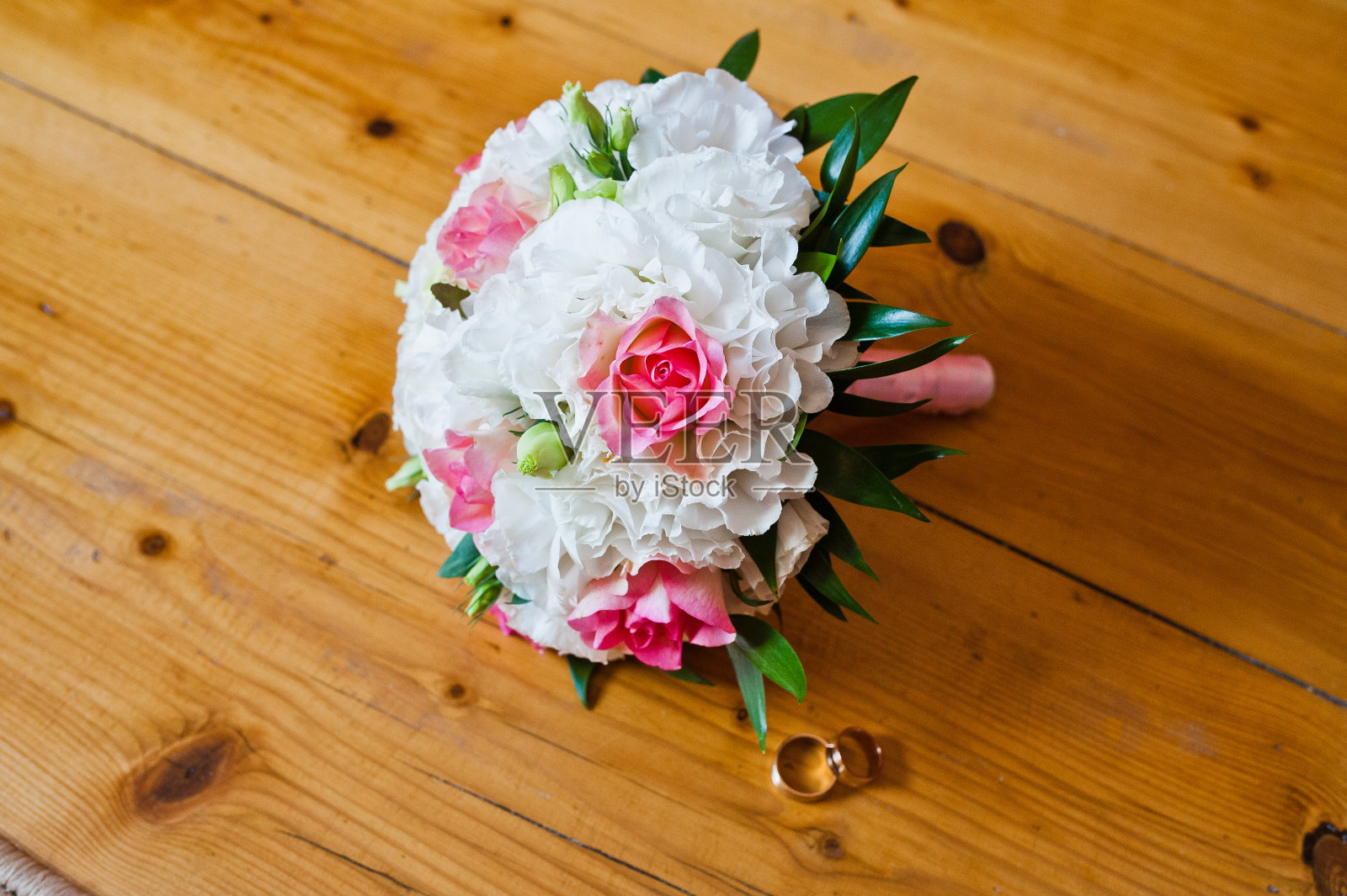 木制背景下的婚花和戒指照片摄影图片