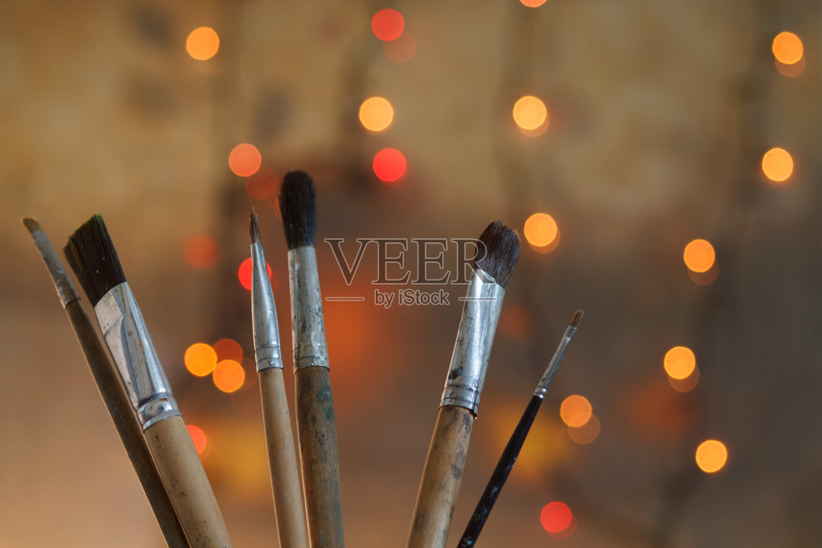 在艺术家的画室里，画笔在抽象艺术的背景上。照片摄影图片