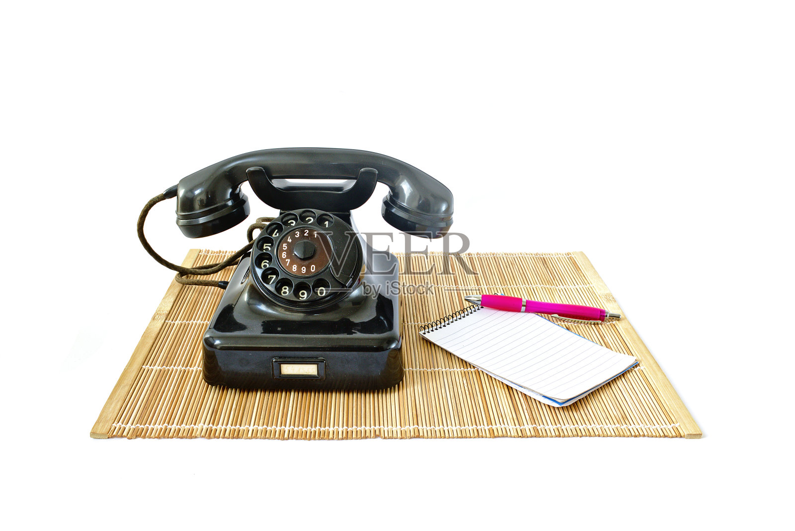 复古电话藤垫与粉红色钢笔和记事本与副本空间隔离在白色背景照片摄影图片