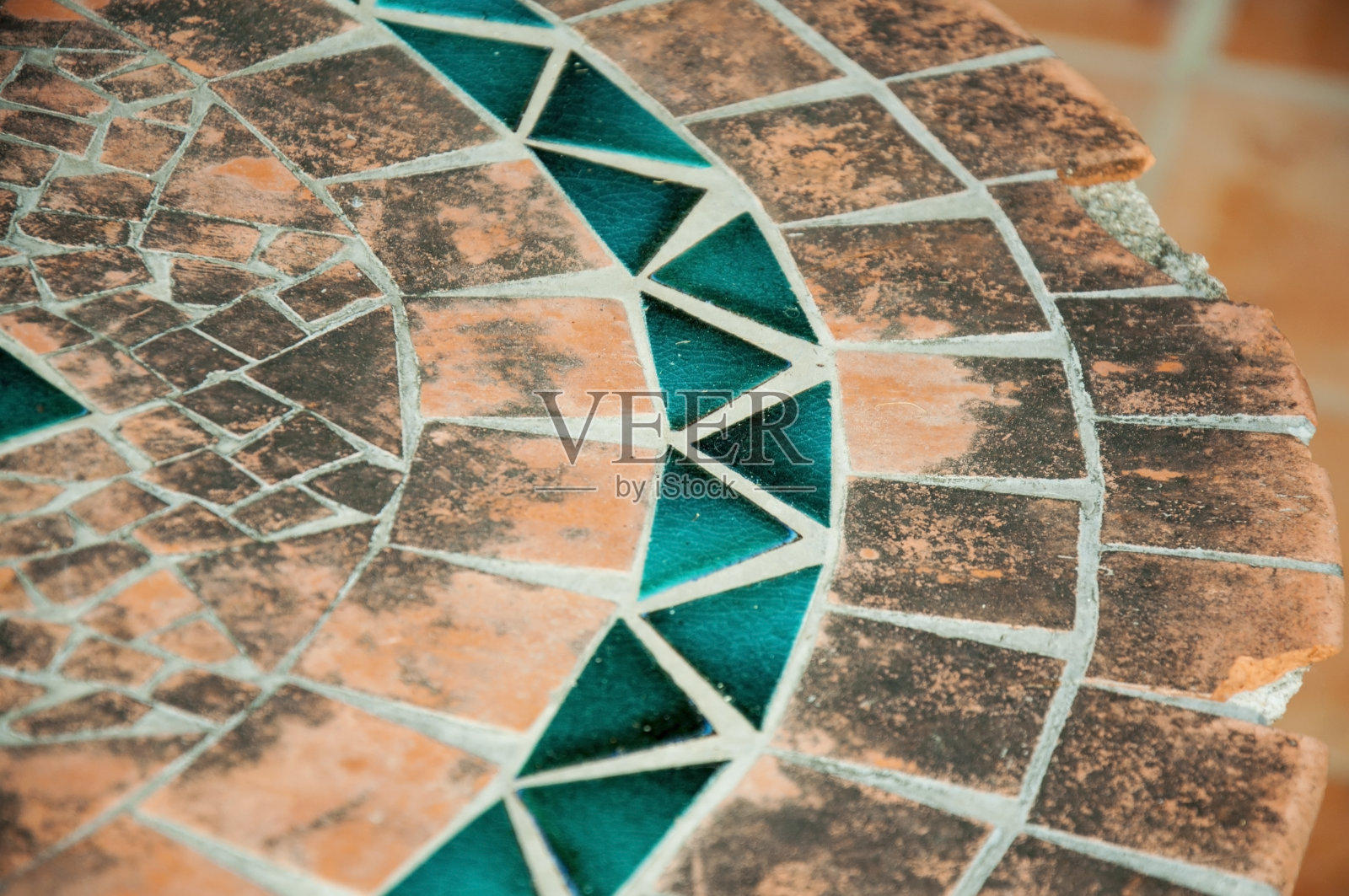 旧桌子上的马赛克元素，橙色和蓝色。照片摄影图片