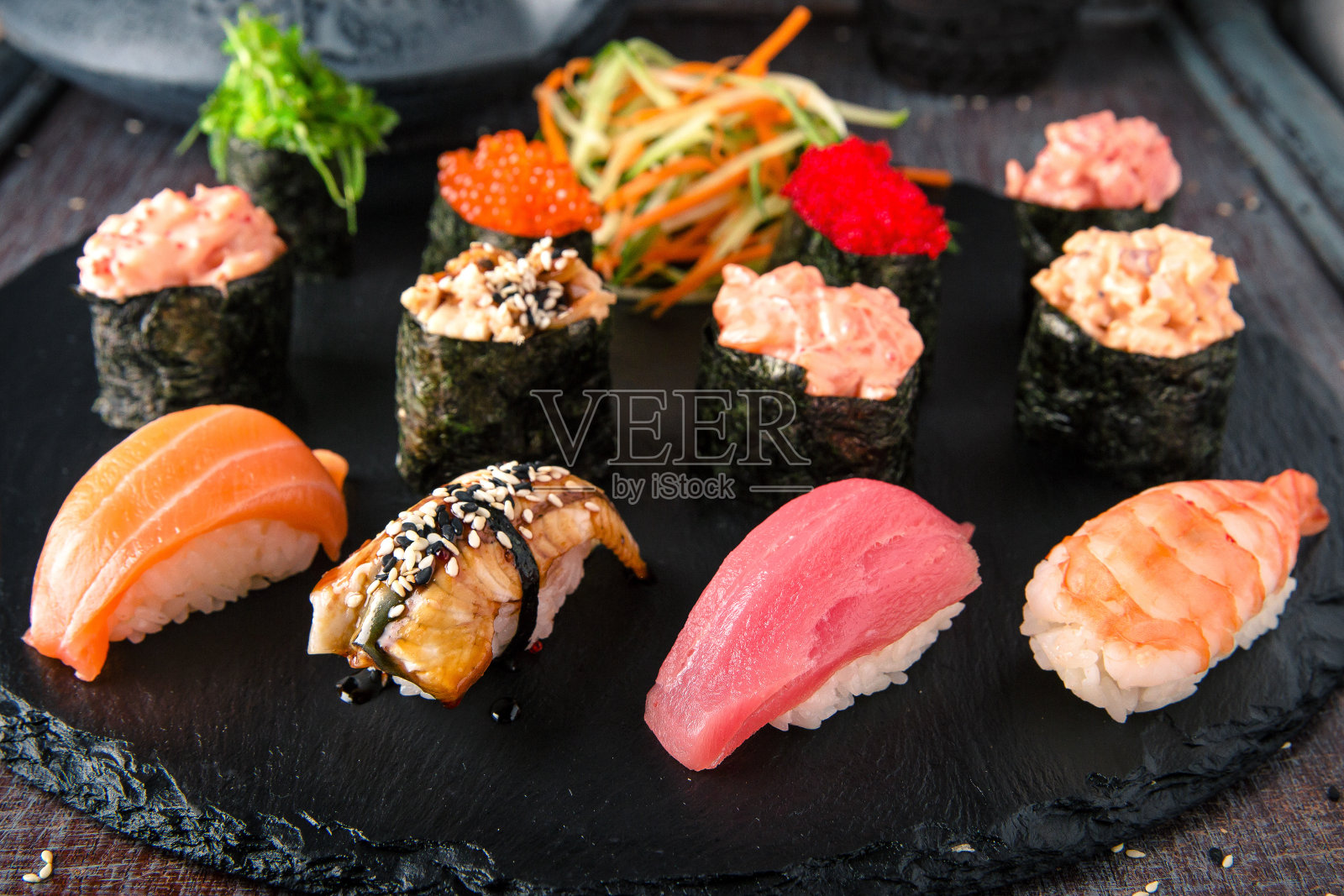 手握寿司配金枪鱼，鲑鱼，鳗鱼和虾。Gunkan寿司。传统的日本料理照片摄影图片