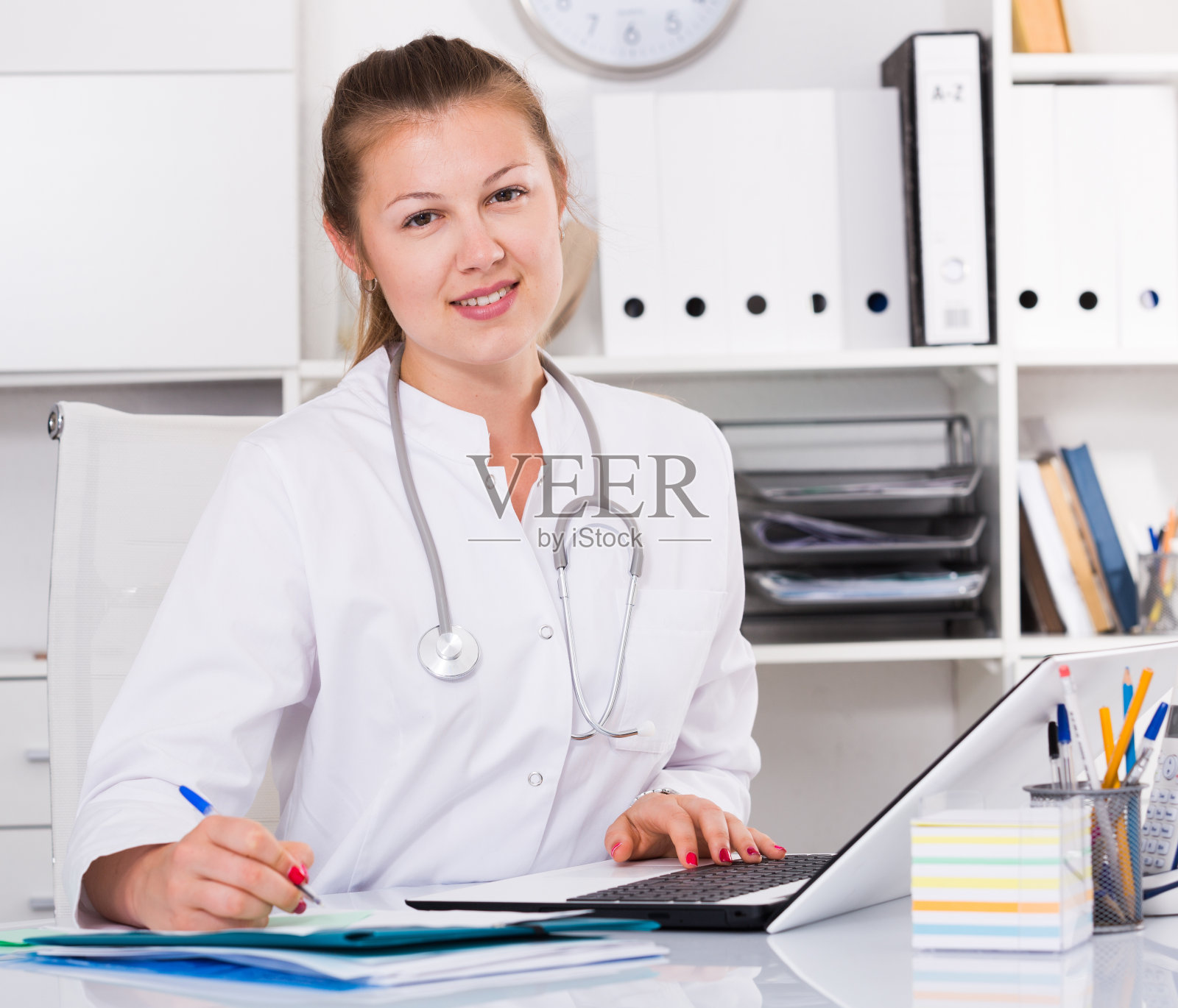 身着制服的女从业人员在笔记本电脑后面处理文件照片摄影图片