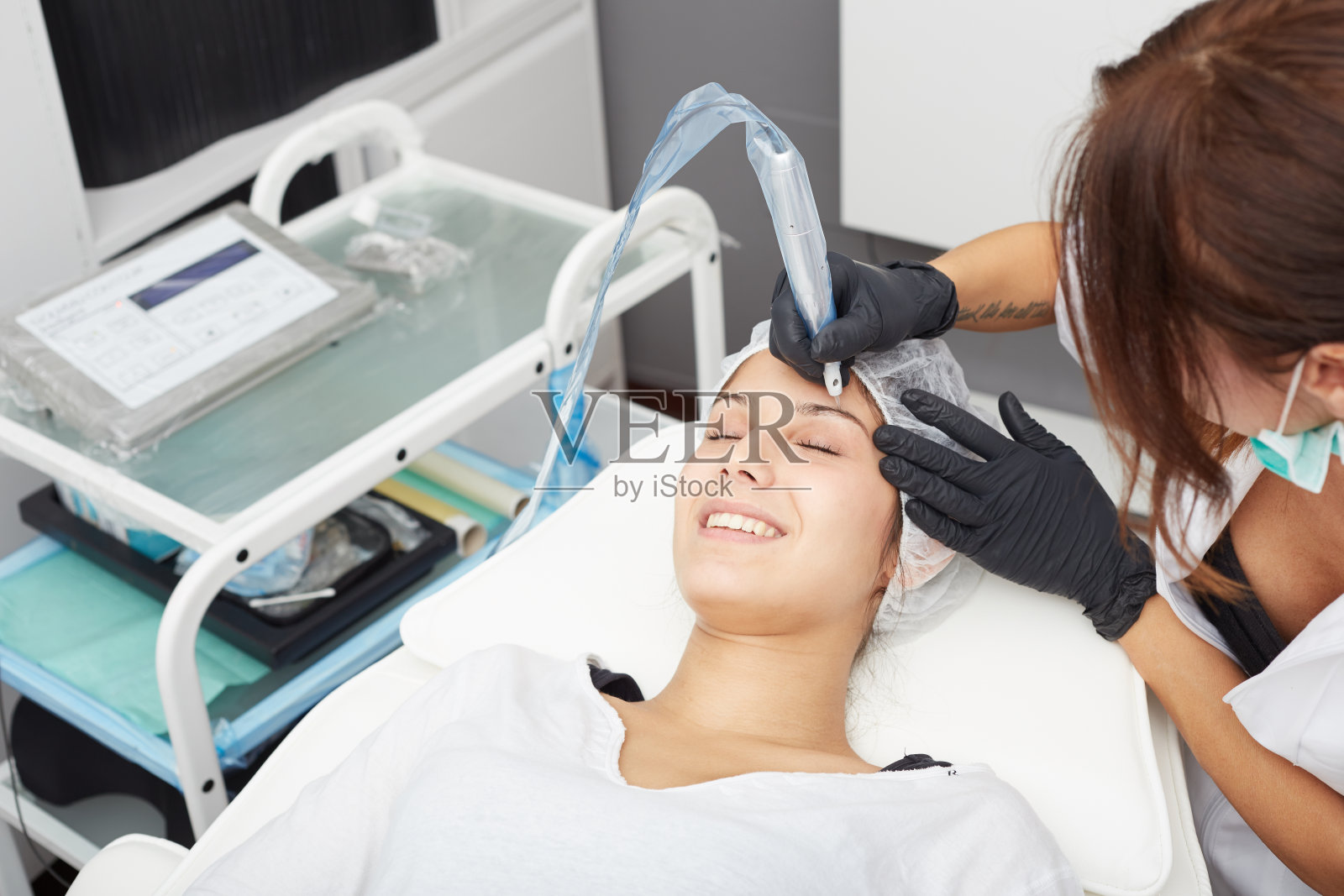 美容师在女人脸上做永久化妆照片摄影图片