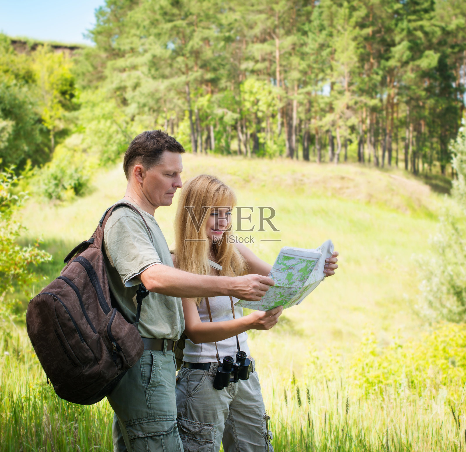 带着地图在森林里徒步旅行的夫妇。照片摄影图片