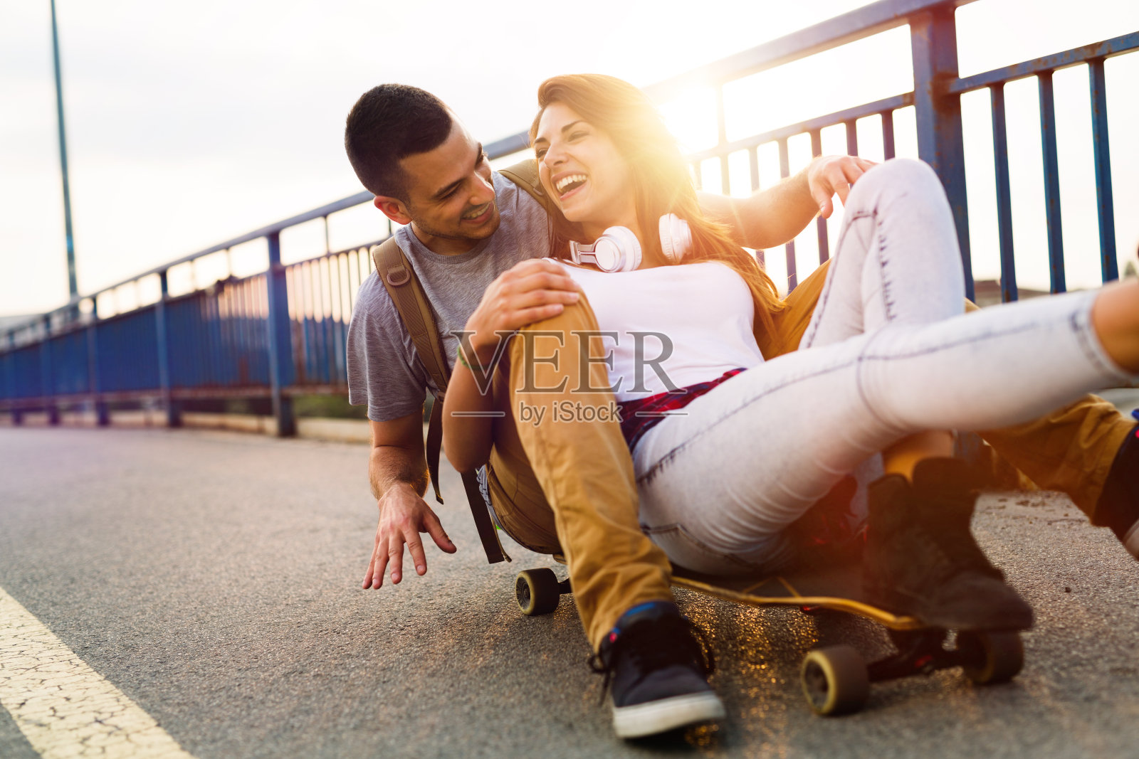 年轻迷人的夫妇骑滑板和有乐趣照片摄影图片