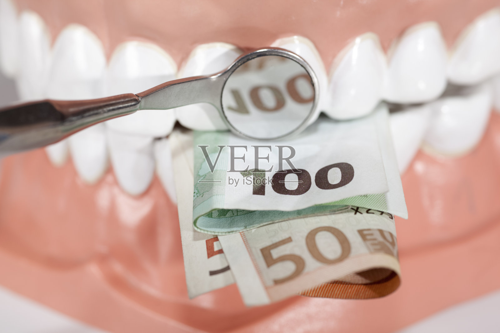 咬着欧元钞票的假牙靠近了照片摄影图片