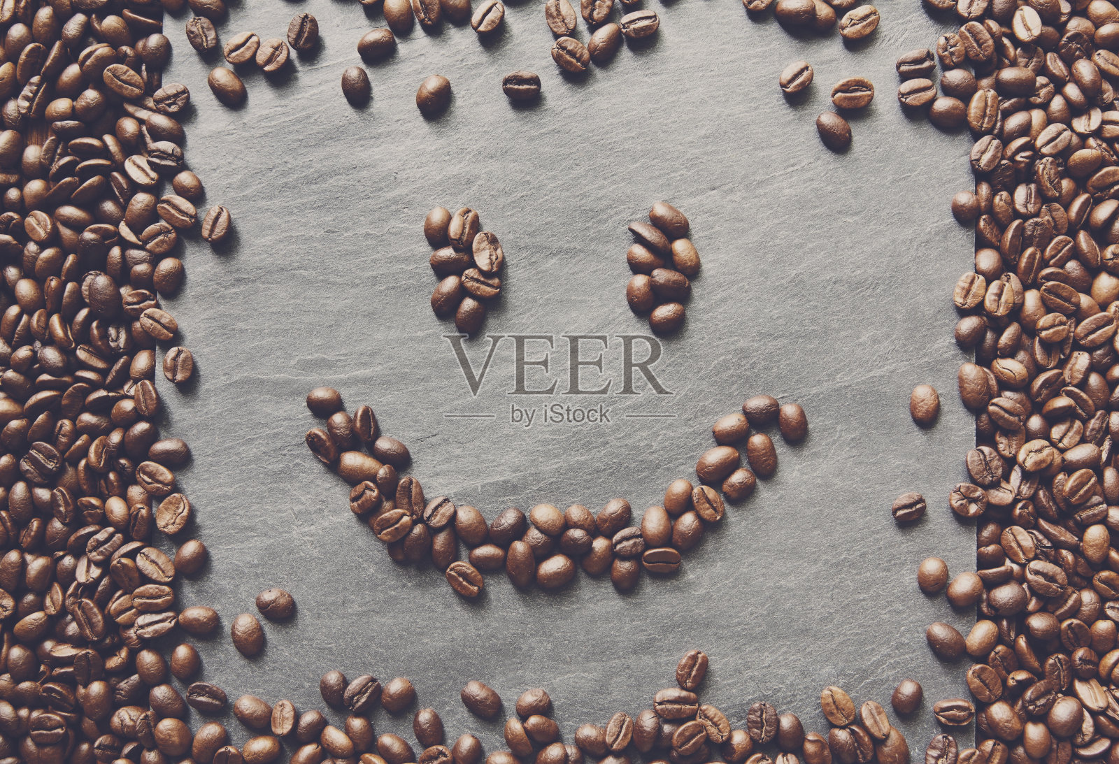 石头背景下的咖啡豆笑脸照片摄影图片