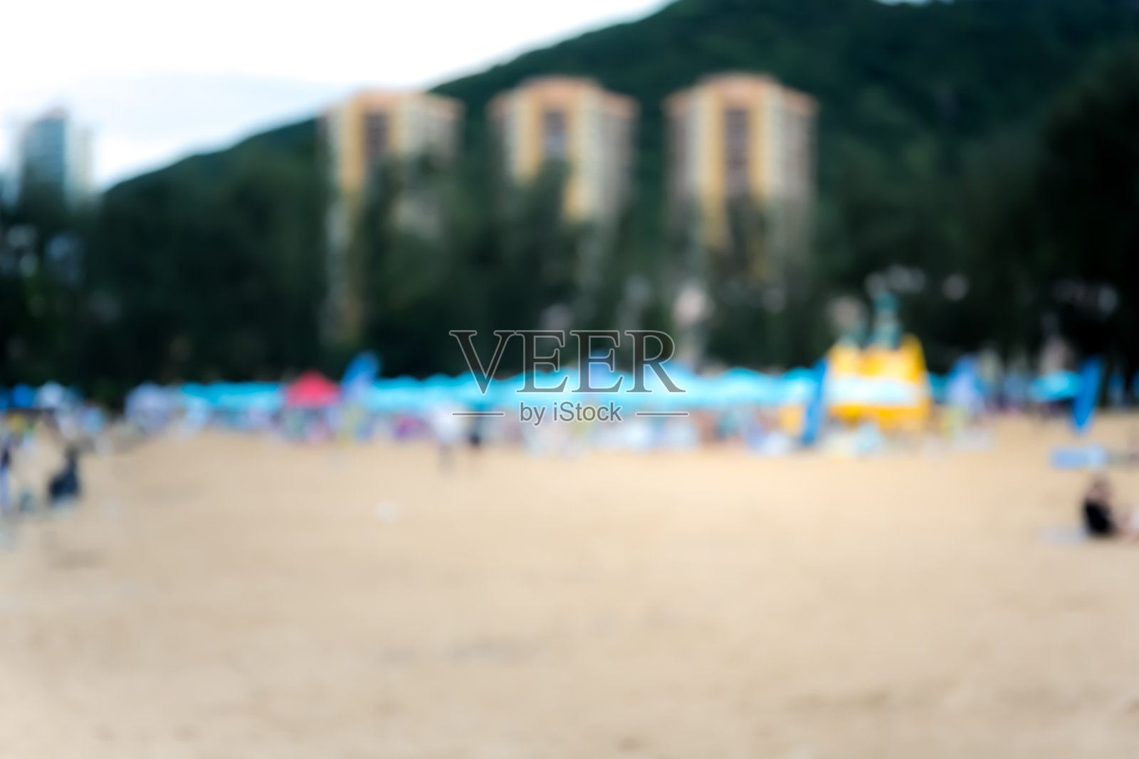 摘要散景背景下的沙滩上的人照片摄影图片