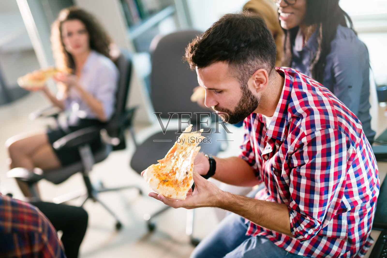 在办公室休息时间吃披萨的同事照片摄影图片