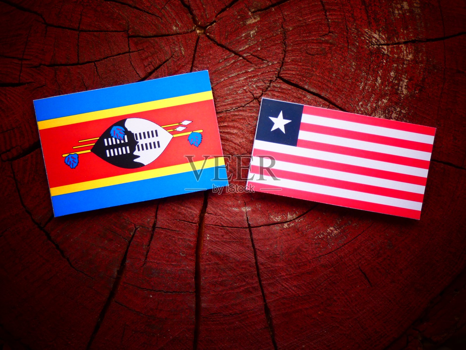 斯威士兰国旗与利比里亚国旗在一个树桩孤立照片摄影图片