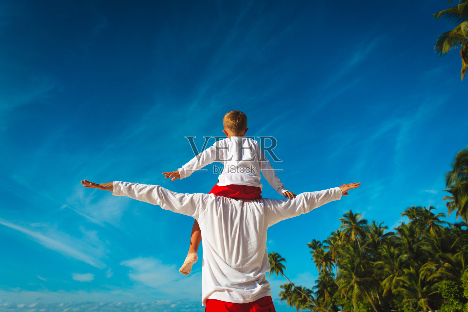 快乐的爸爸和儿子在肩膀上玩天空照片摄影图片