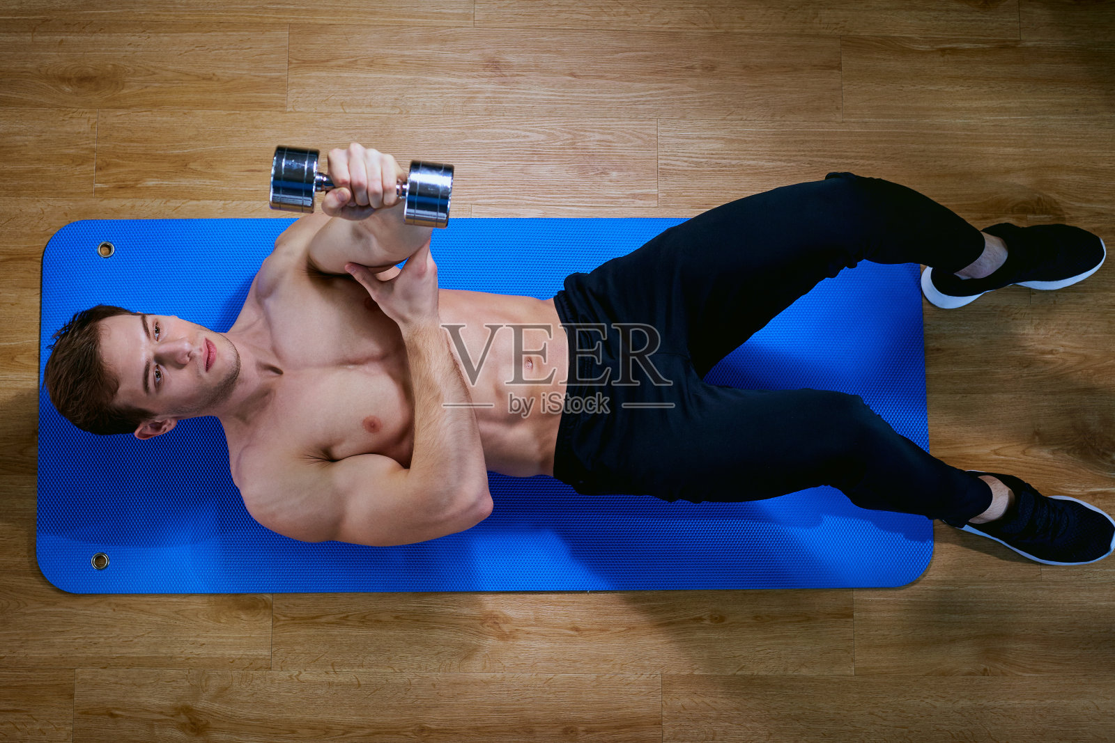 顶视图的运动。男运动员在地板上做运动训练照片摄影图片